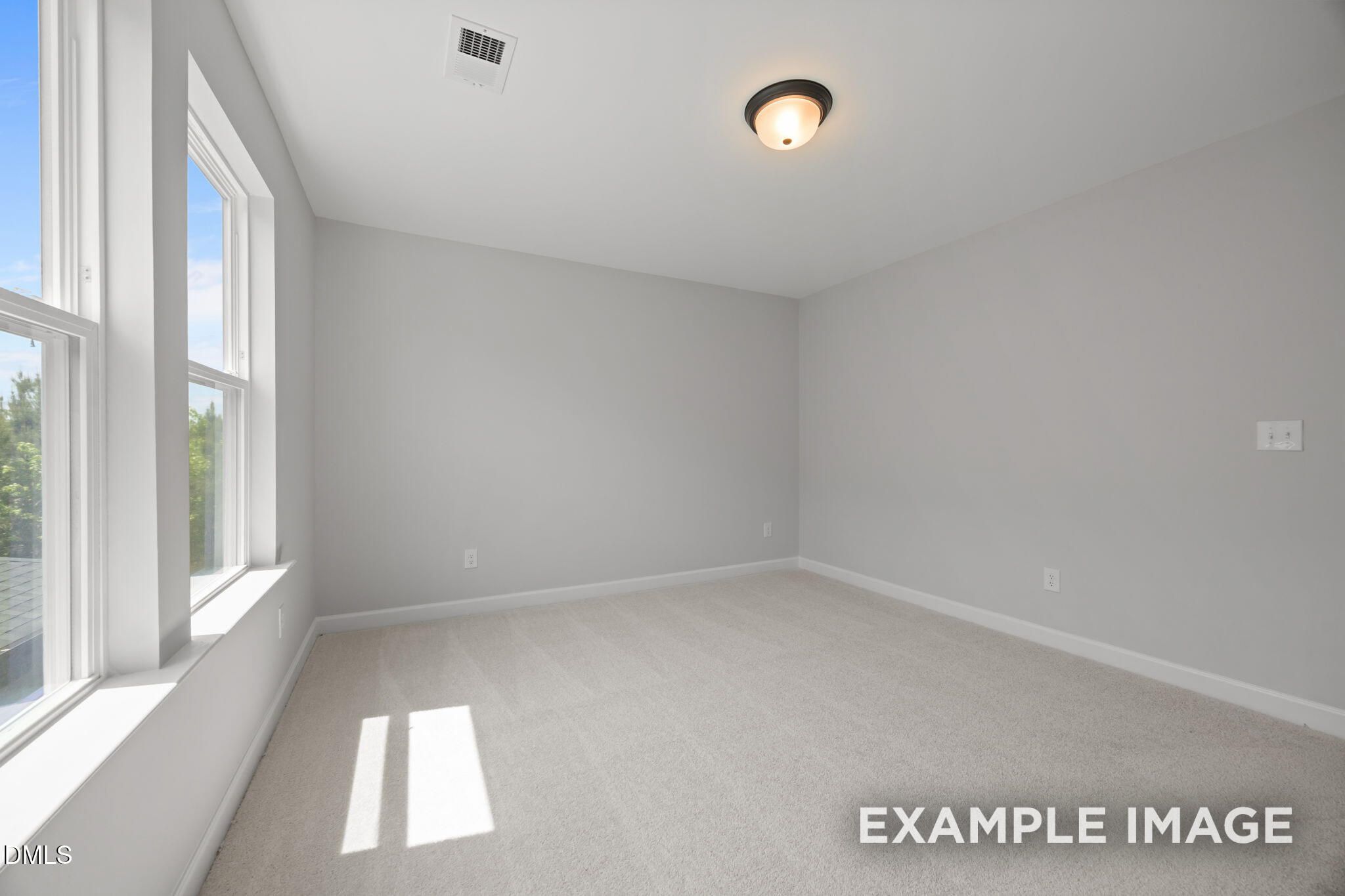Bright bedroom with plush carpet and large windows in Davidson Homes The Beech plan at Wendell Ridge, Wendell, NC