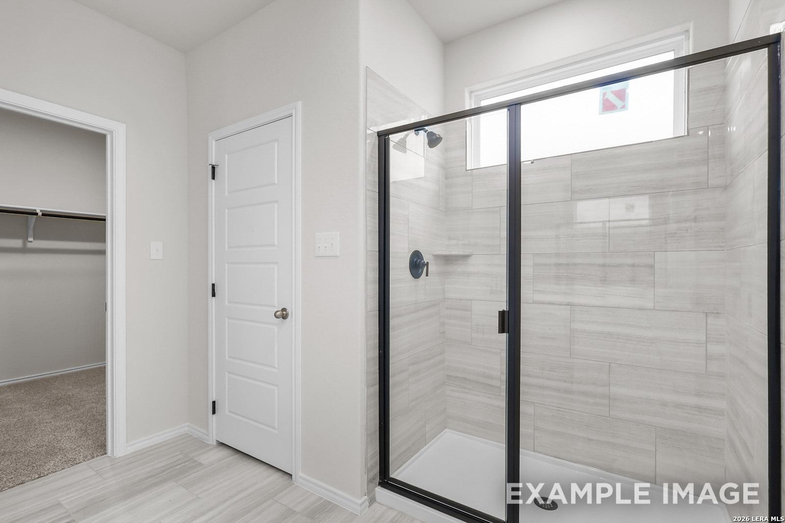 Tiled walk-in shower with glass enclosure in The Sequoia C floor plan by Davidson Homes in Royal Crest, San Antonio.