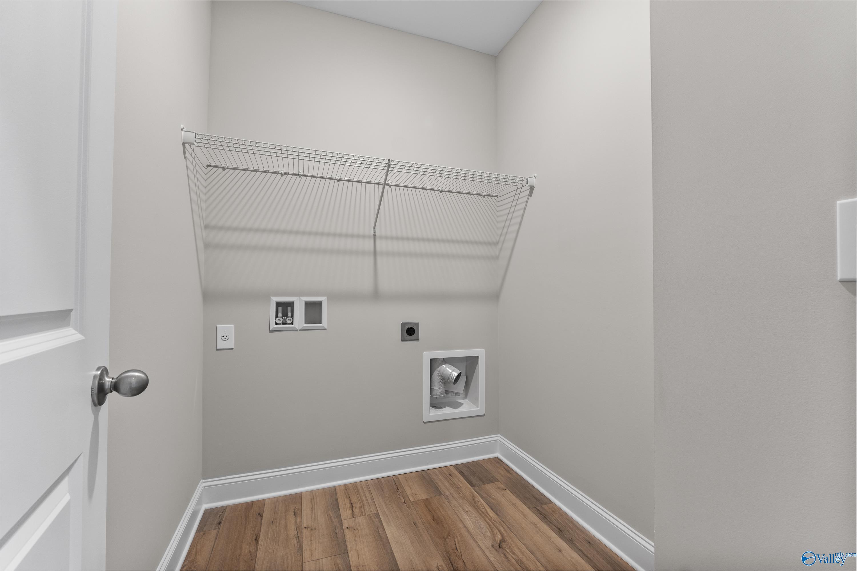 Spacious laundry room with washer dryer hookups, wire shelving and hardwood floors in Davidson Homes The Daphne C, Harvest Alabama