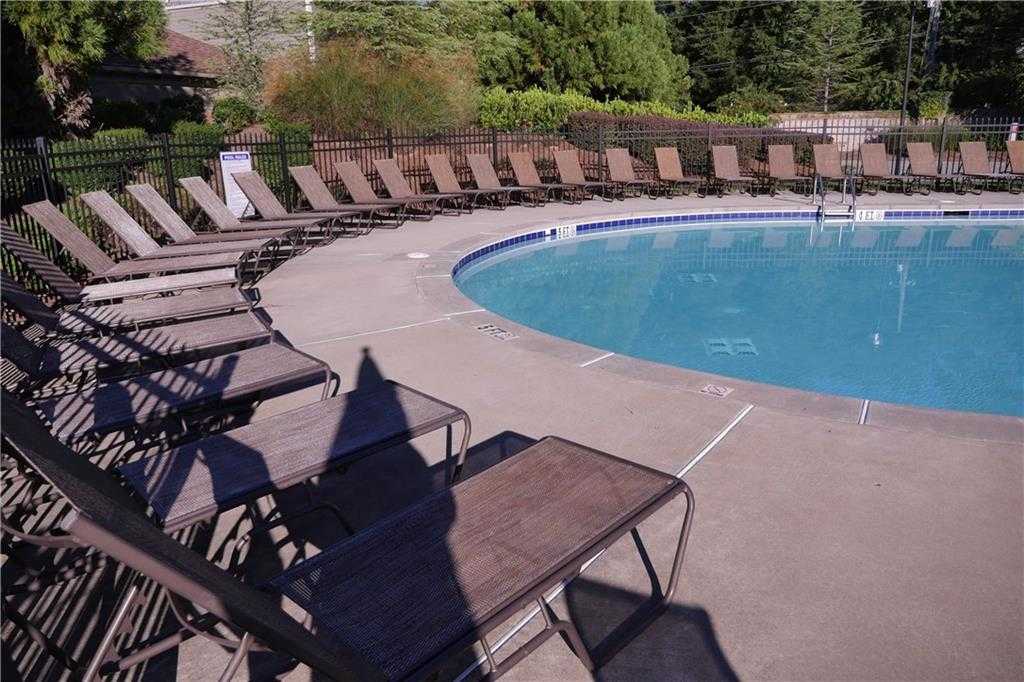 Community pool with lounge chairs and black fence at The Village at Towne Lake, Woodstock, Georgia