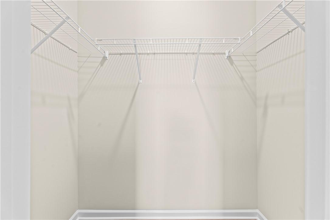 Spacious walk-in closet with white wire shelving in master suite of Evermore Homes The Orion, Cusseta, Alabama