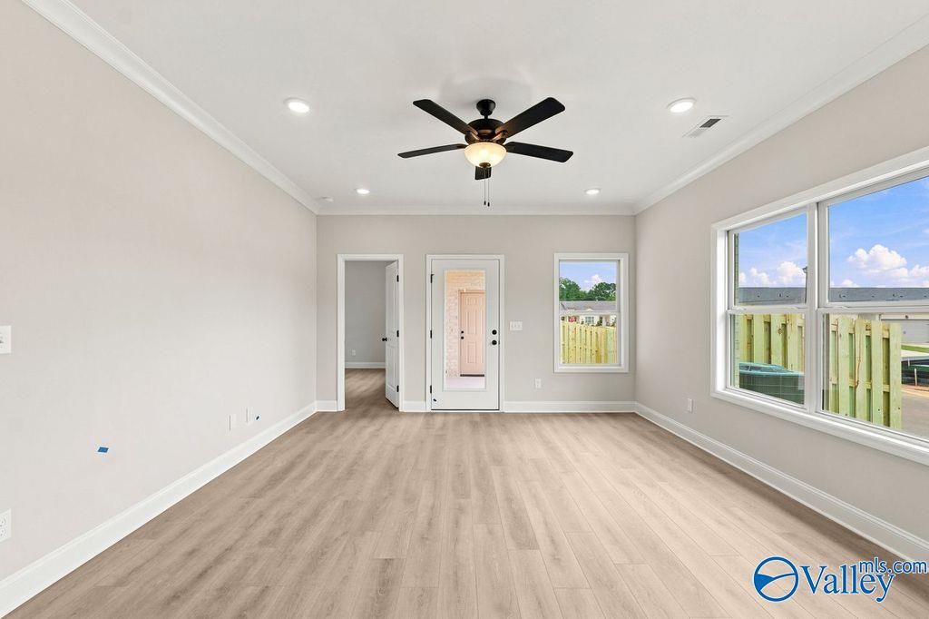 Bright, open-concept living area with wood-style flooring in The Camilla B floor plan at The Retreat at Cain Park.