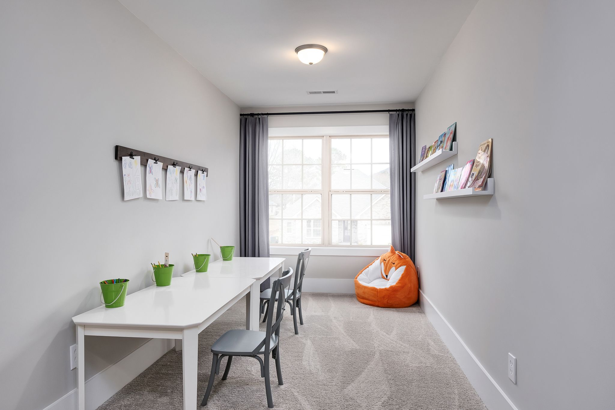 Cozy kids' study room at Chimney Creek in Hampton Cove Alabama with white craft table bulletin board and orange bean bag