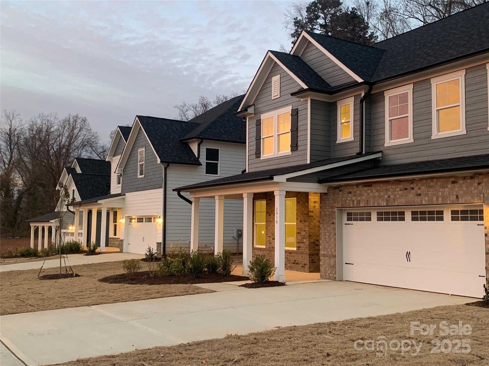 Modern two-story homes with brick accents, covered porches, and two-car garages in Enclave at Belmont, North Carolina