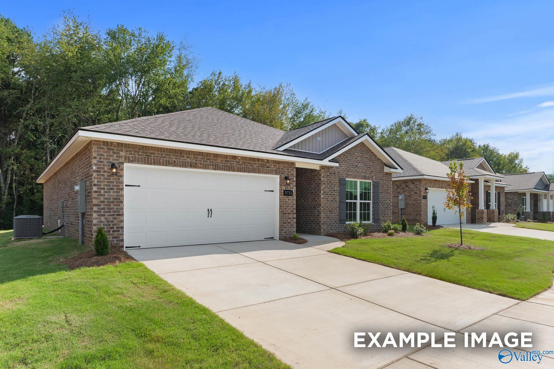 Modern 1-story brick home with 2-car garage, driveway, and landscaped yard in Wood Trail, Toney, Alabama - Davidson Homes Asheville
