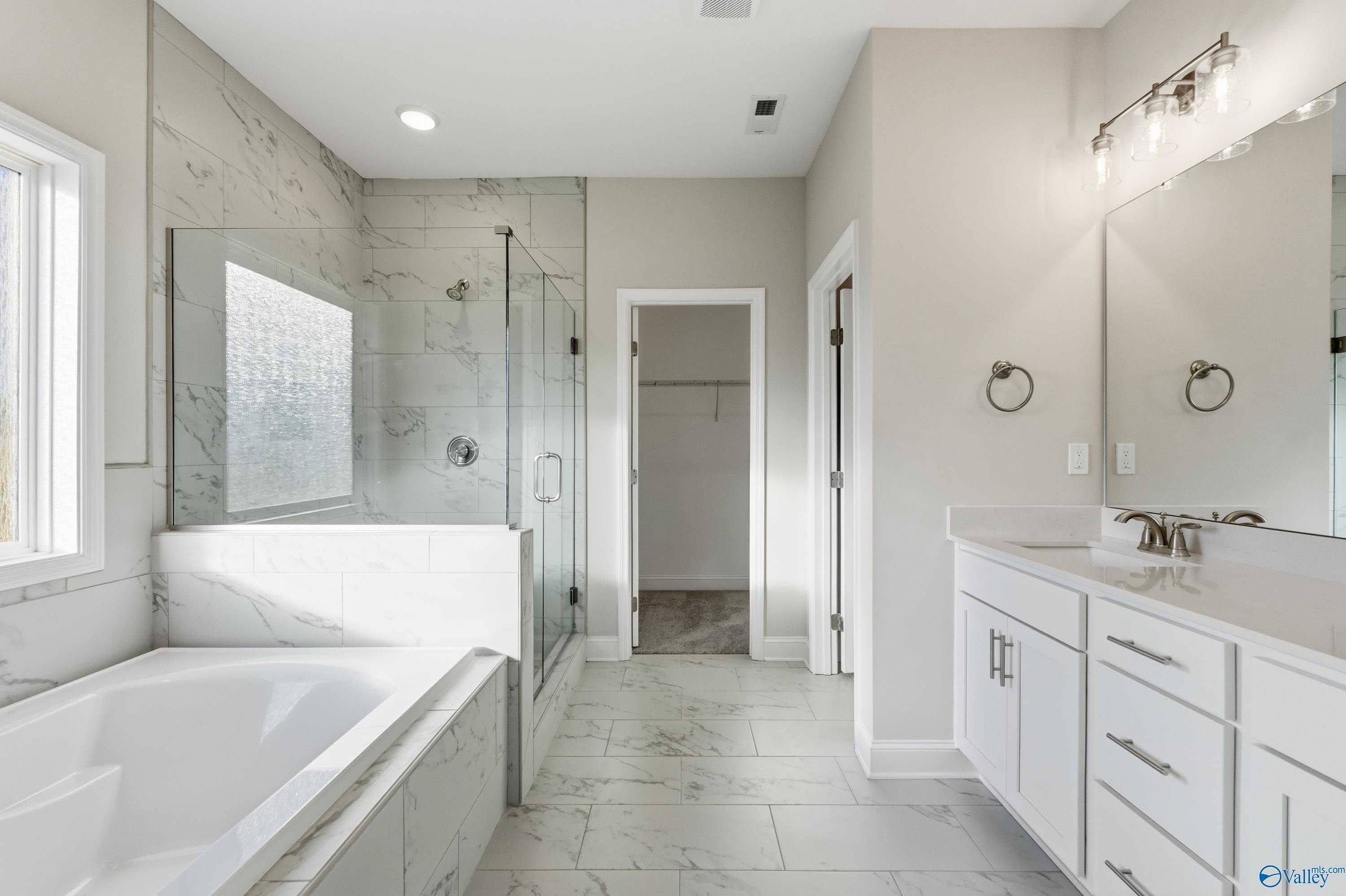 Luxurious master bathroom with freestanding tub, glass-enclosed shower, double vanity in Davidson Homes The Montgomery B, Toney, Alabama