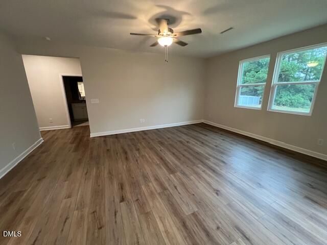 Spacious living room with wood-look flooring, ceiling fan, and natural light in Davidson Homes The Willow D, Wellers Knoll, Lillington NC