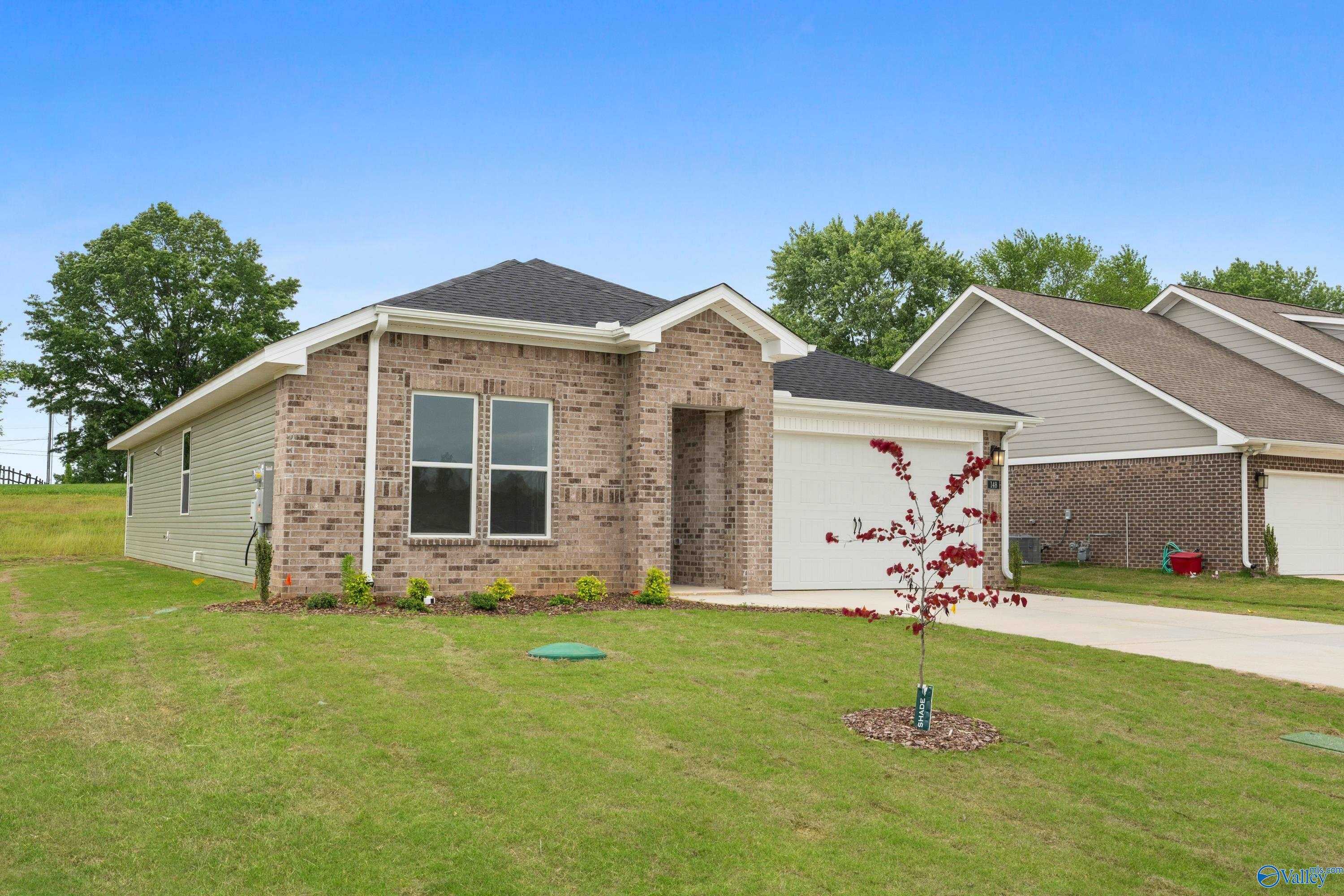 Modern brick single-story home with 2-car garage, large windows, and landscaped yard in Bailey Park, Fayetteville, Tennessee - Davidson Homes The Phoenix