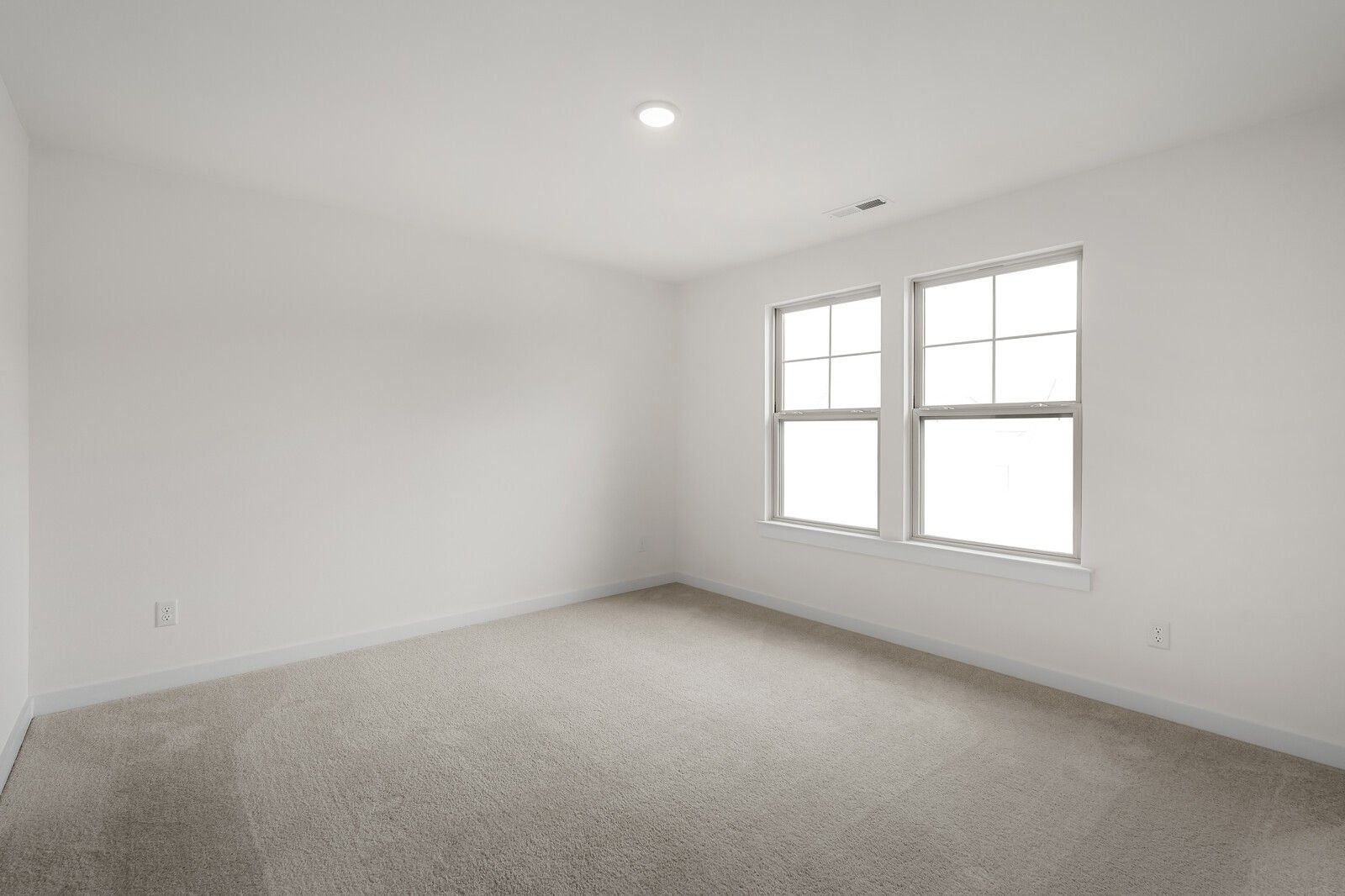 Spacious empty bedroom with beige carpet, white walls, and double windows in Davidson Homes The Willow C, Gallatin, TN