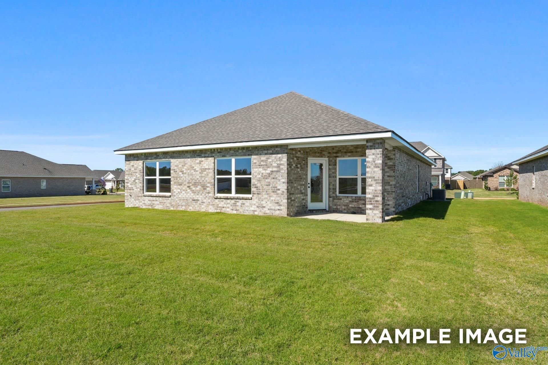 Single-story brick 4-bedroom home with large windows, gabled roof, and lush green lawn in Ricketts Farm, Athens, Alabama - Davidson Homes Daphne C