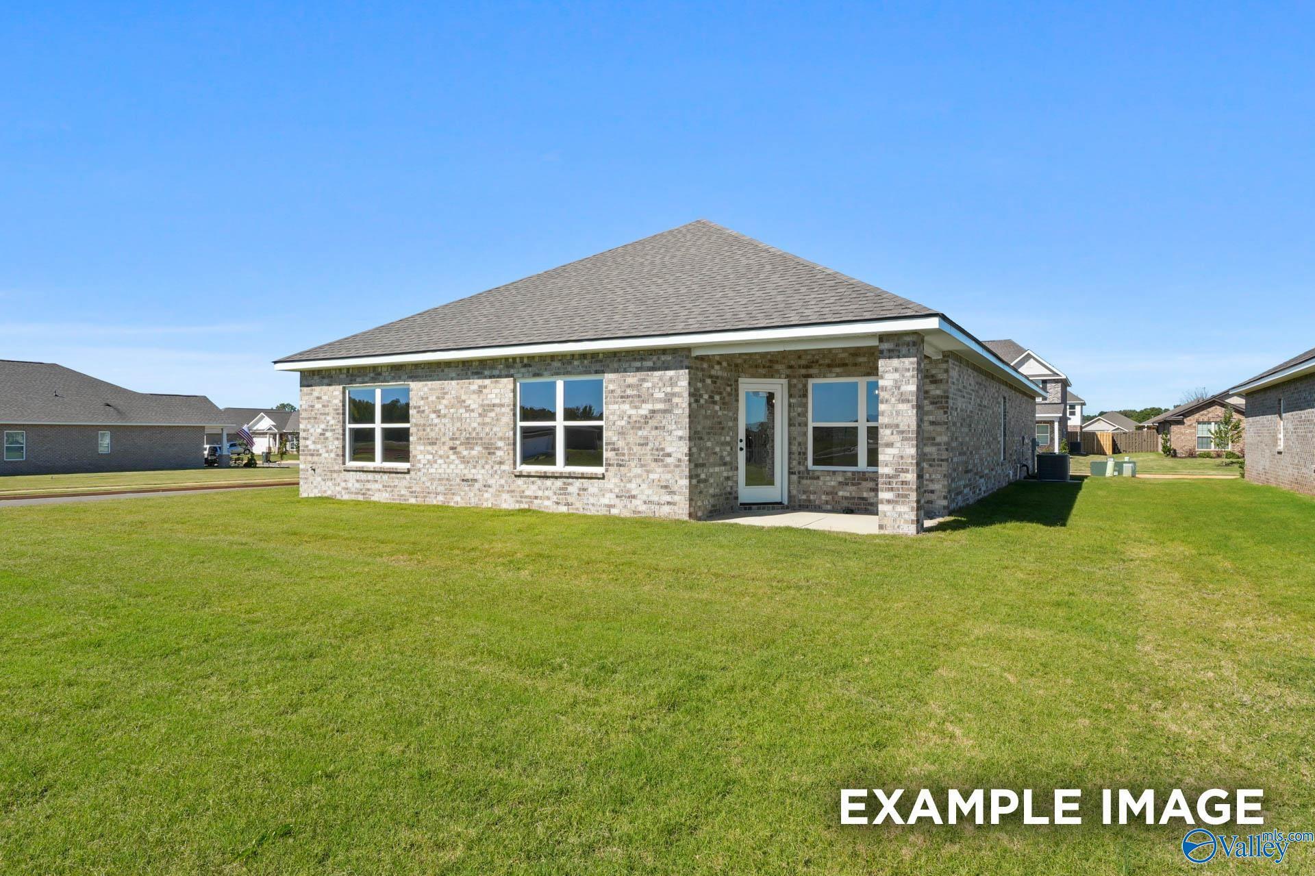 Single-story brick 4-bedroom home with large windows, gabled roof, and lush green lawn in Ricketts Farm, Athens, Alabama - Davidson Homes Daphne C