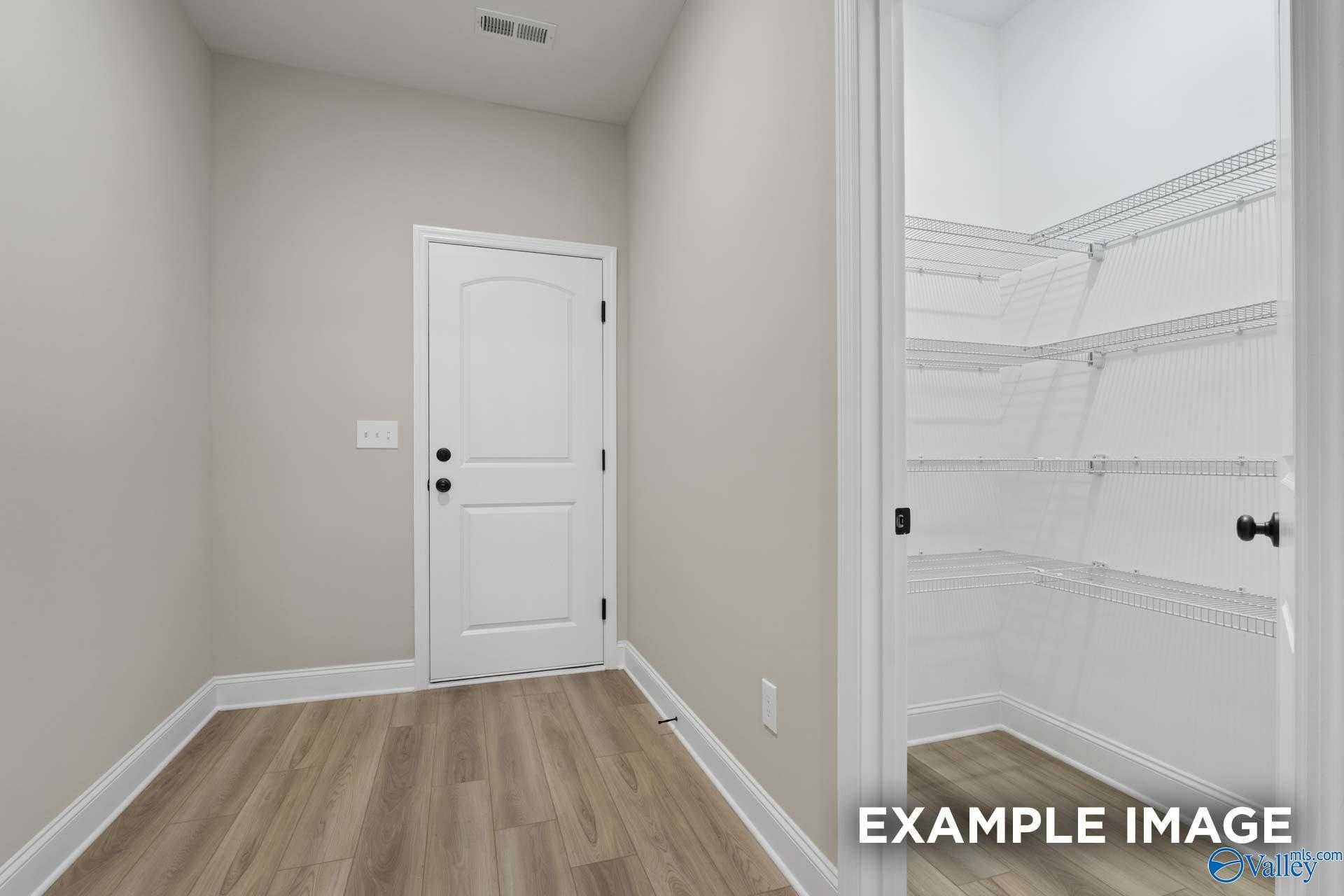 Walk-in closet with wire shelving and white doors in bedroom of The Camden D floor plan by Davidson Homes, Huntsville AL