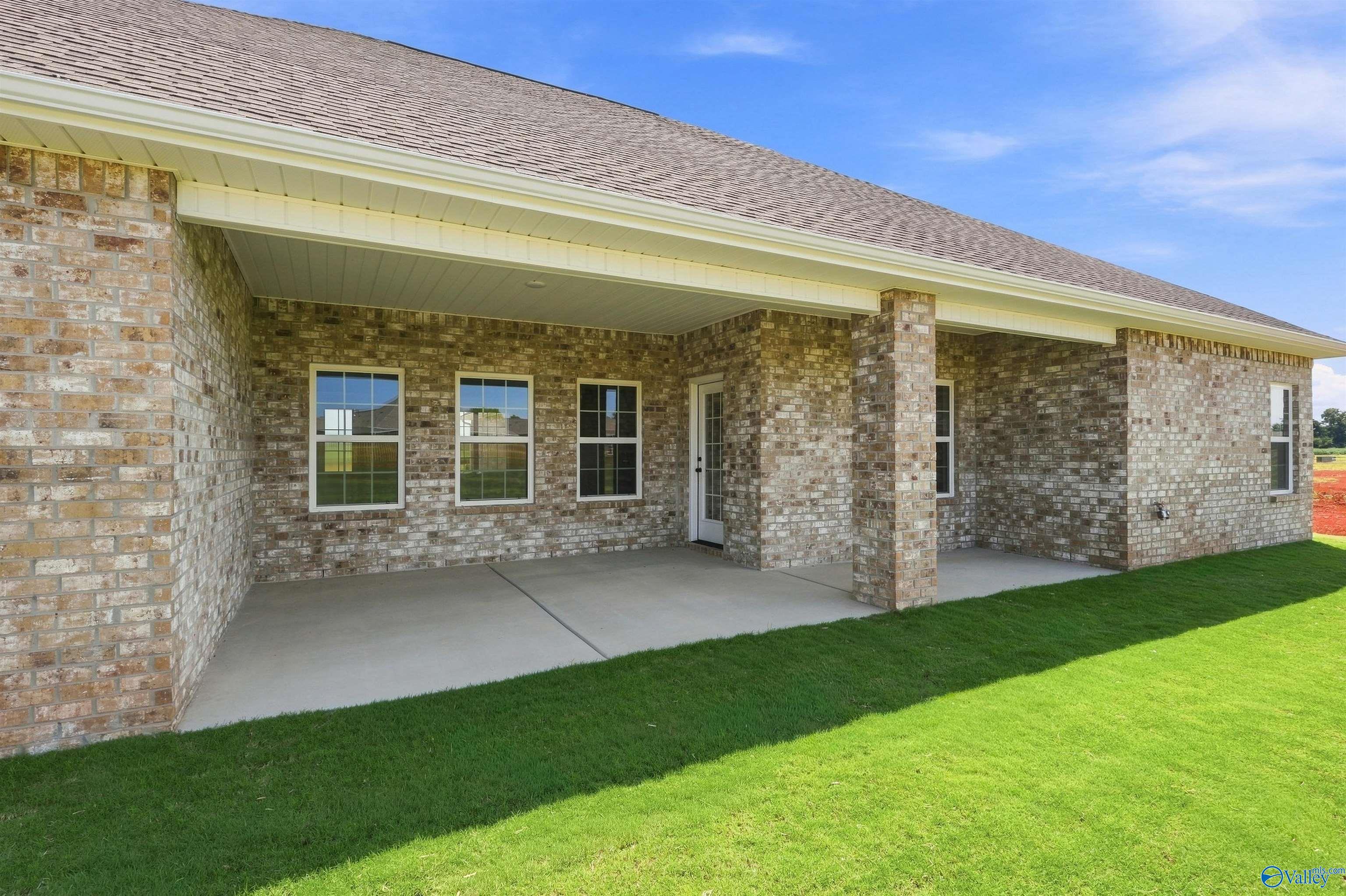Covered brick patio and backyard of The Oxford floor plan by Davidson Homes in Kendall Farms, Toney, Alabama.