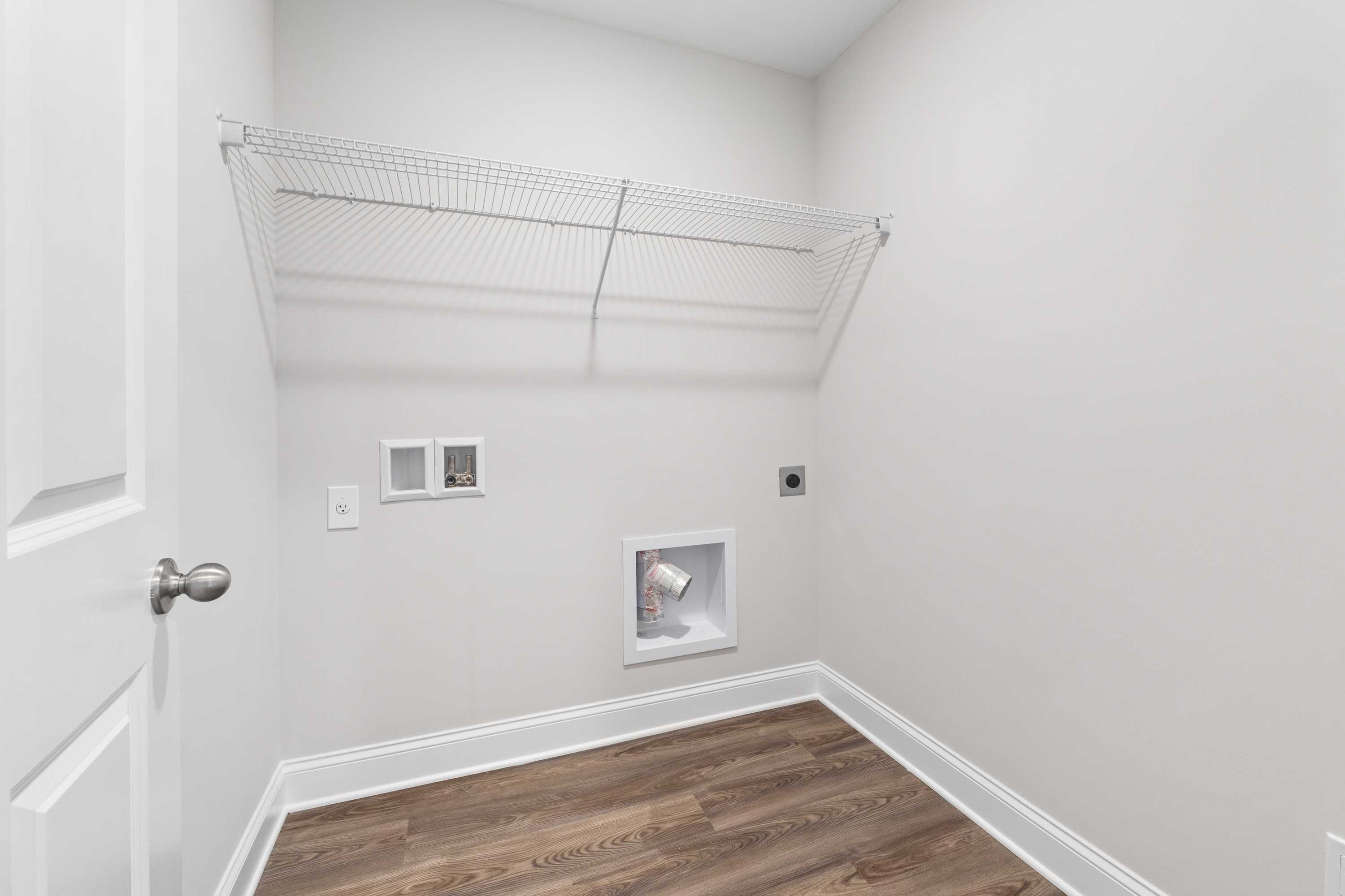 Spacious laundry room in Chapel Hill Athens Alabama with wire shelving, washer dryer hookups, and pet door