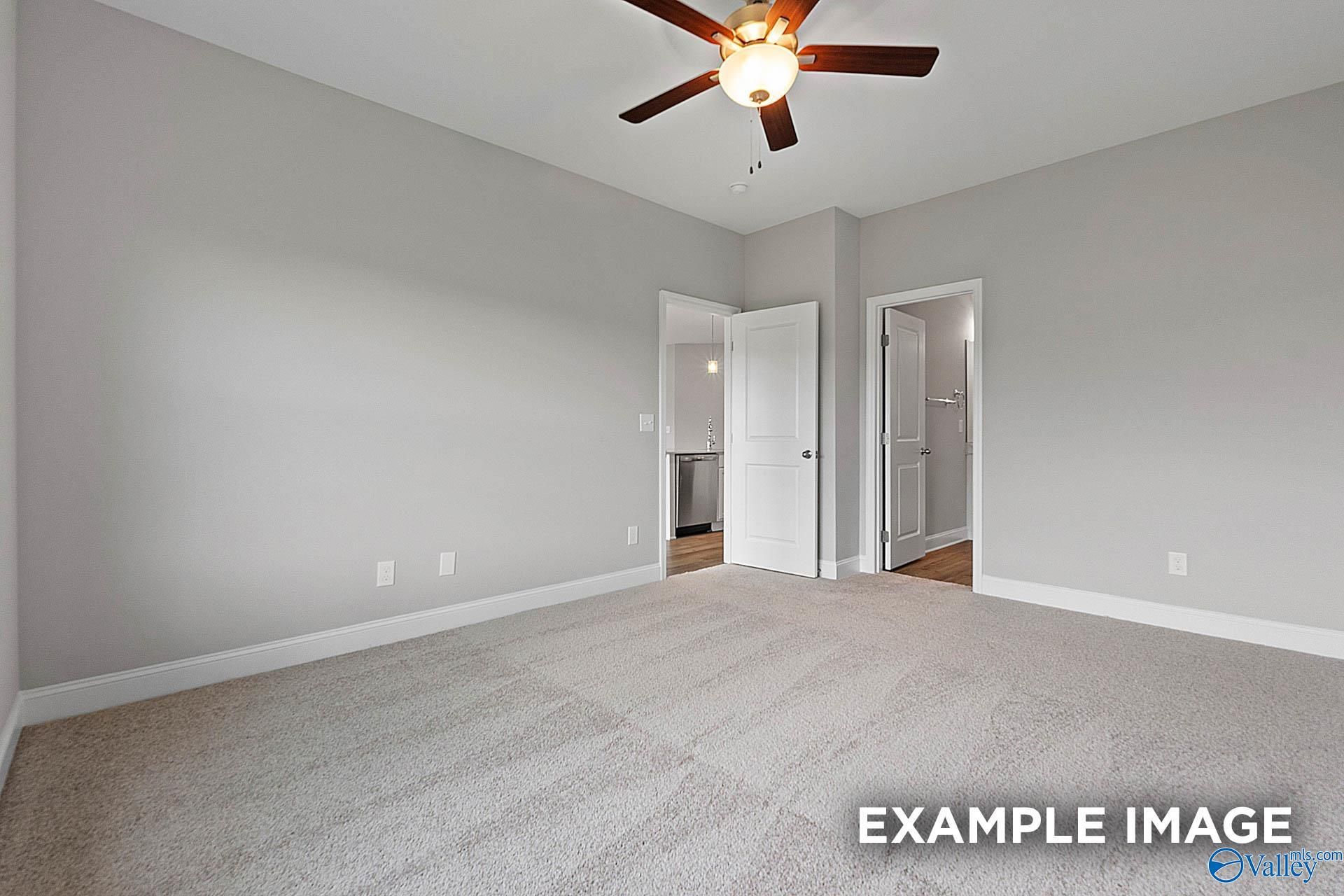 Master bedroom with ceiling fan, gray walls, carpeted floor, open bathroom door in Davidson Homes The Franklin E, Hazel Green, Alabama