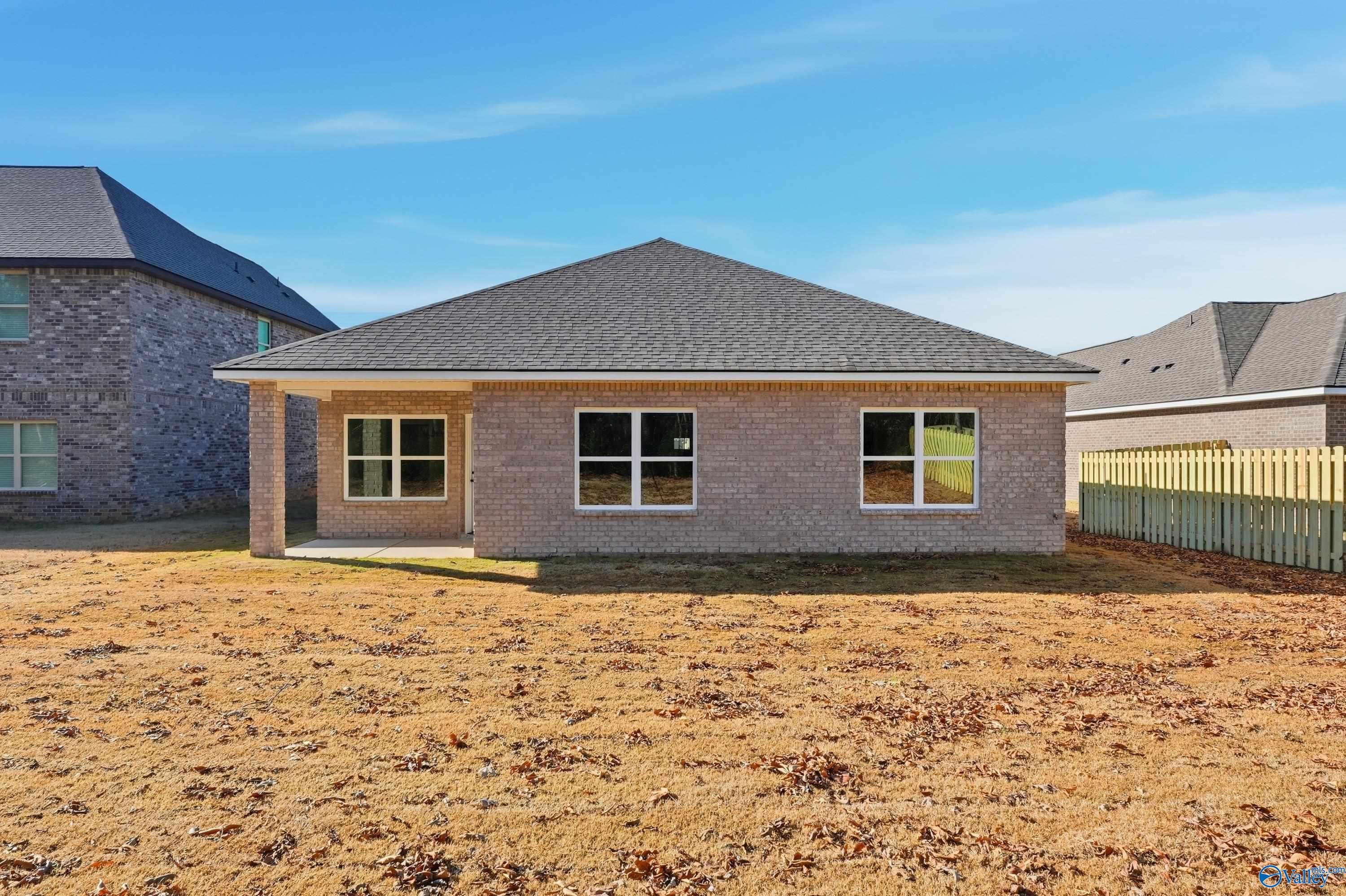 Single-story brick 4-bedroom home with covered porch, gabled roof, and fenced backyard in Creek Grove, New Market, Alabama