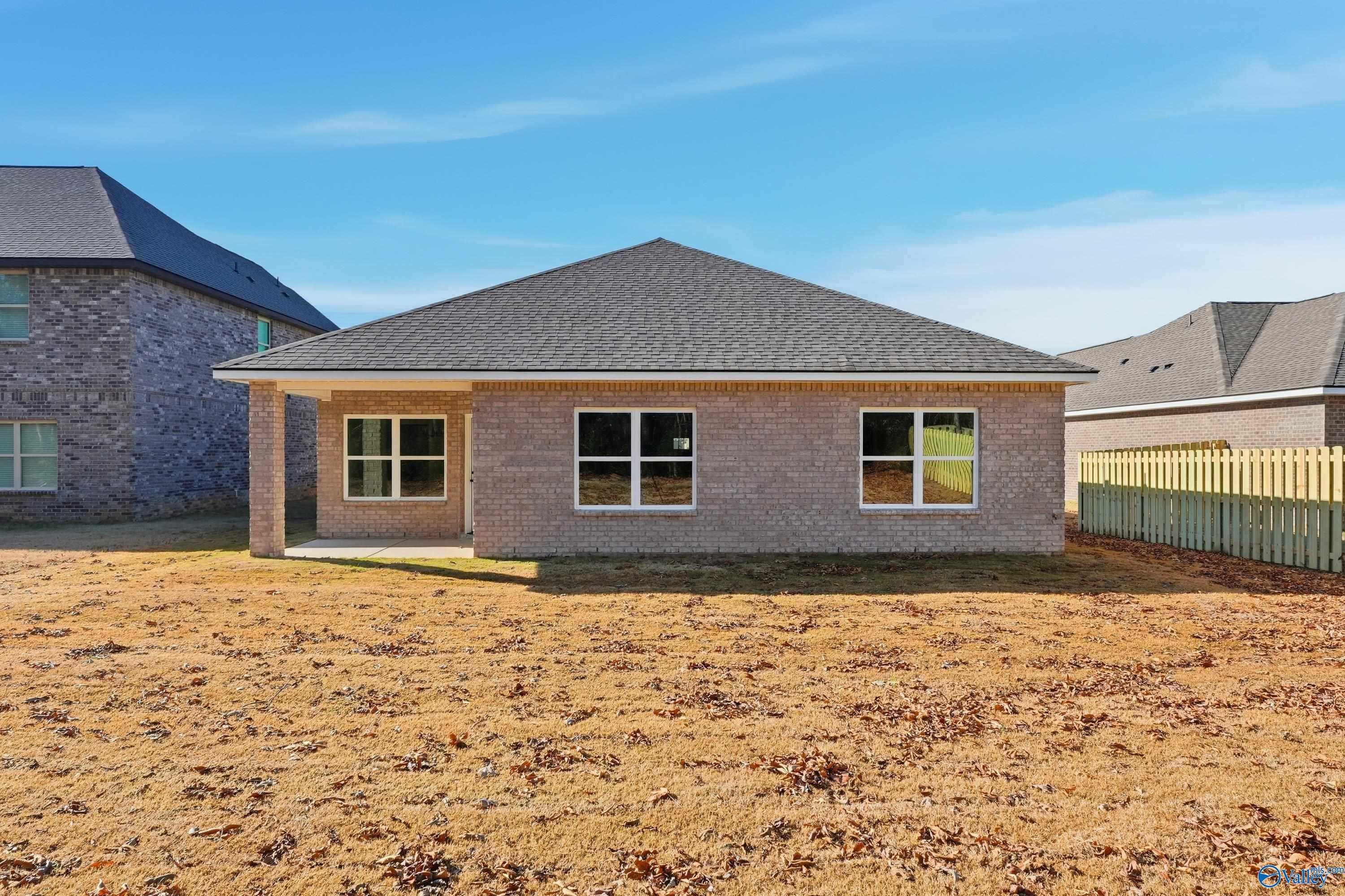 Single-story brick 4-bedroom home with covered porch, gabled roof, and fenced backyard in Creek Grove, New Market, Alabama