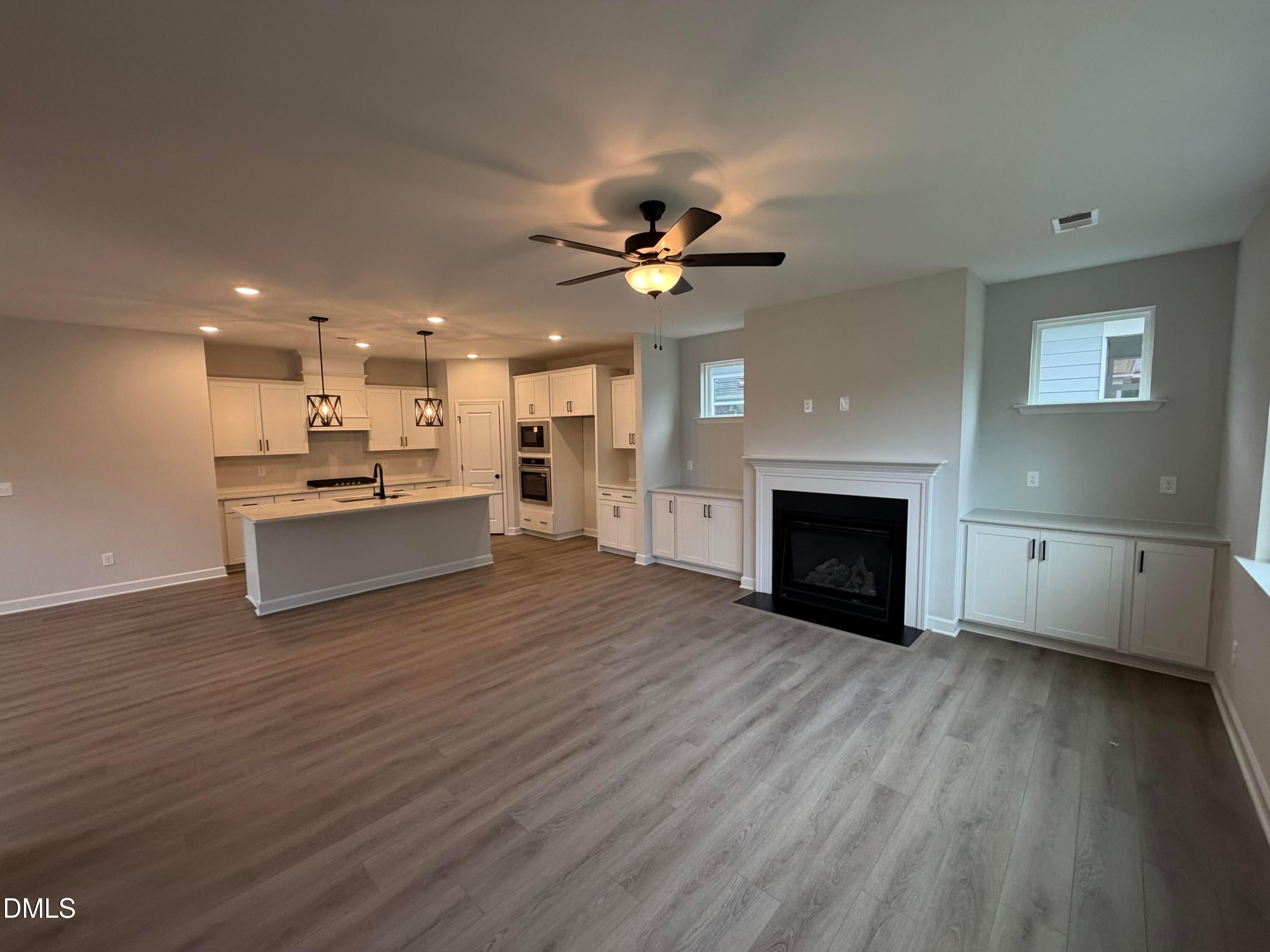 Open-concept living room with gas fireplace and kitchen with island in Davidson Homes Preston C plan, Wendell, NC