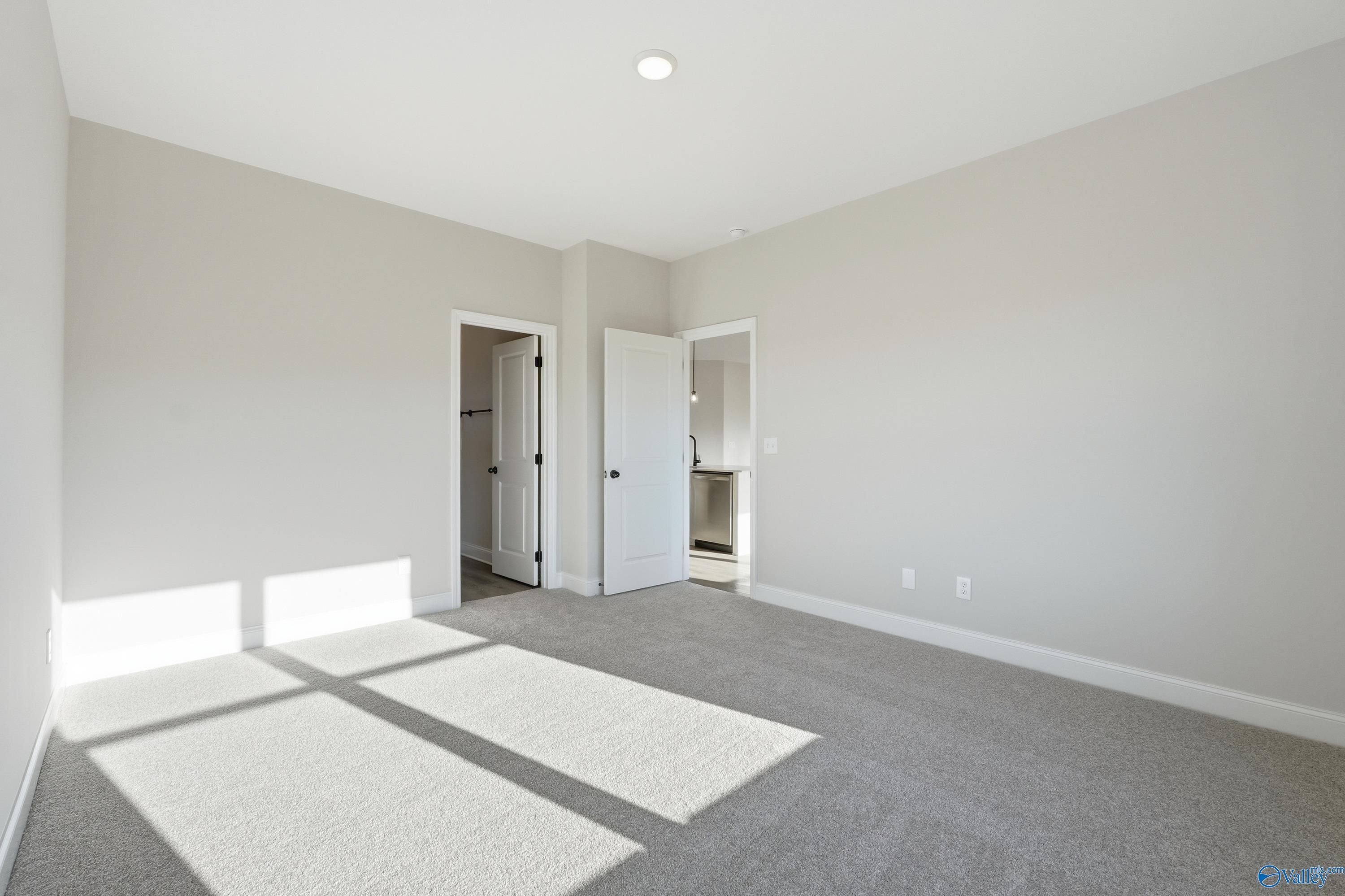 Bright secondary bedroom with gray carpet, neutral walls, en-suite door, and natural light in Davidson Homes The Franklin E, Hazel Green AL