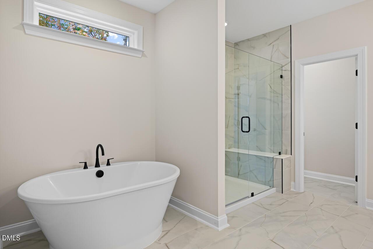 Freestanding soaking tub and glass walk-in shower in Davidson Homes Crawford D master bath, Rockport, Wake Forest, NC