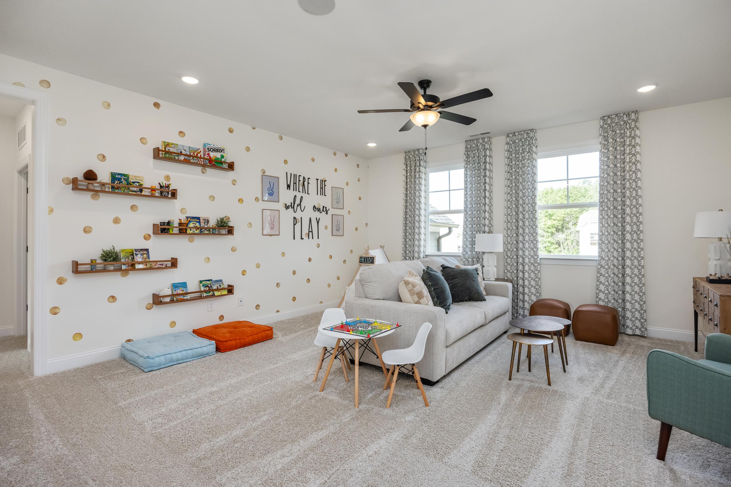 Cozy playroom at Laneridge Estates in Raleigh NC with polka dot walls, bookshelves, kids table, sofa and ceiling fan