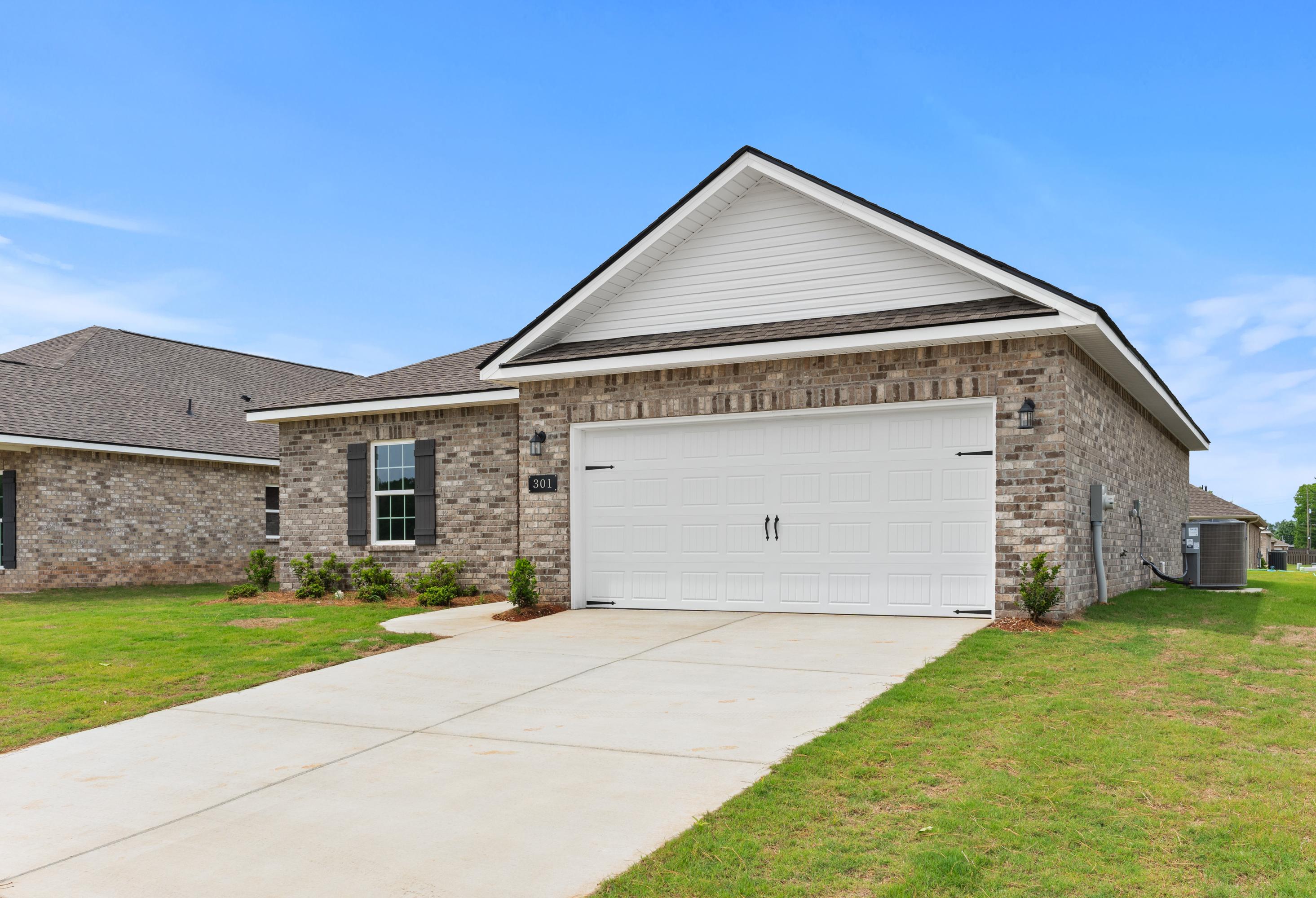 Front elevation of The Butler single-story home by Davidson Homes, featuring brick siding, 2-car garage, and lush lawn in Meridianville, AL