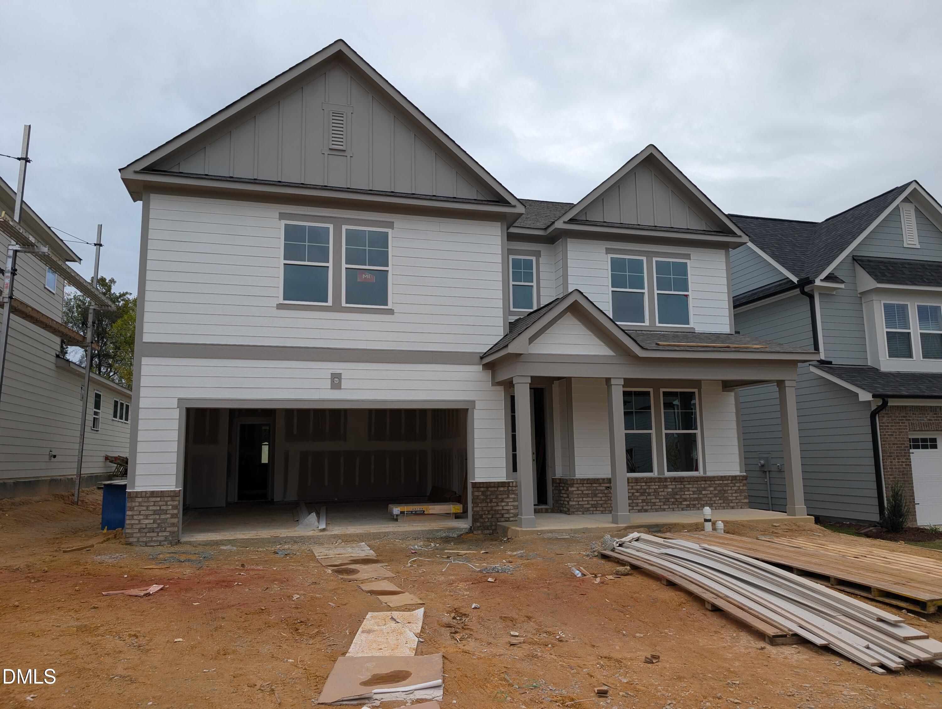 Two-story white new construction home with covered front porch and 2-car garage at Wendell Ridge by Davidson Homes