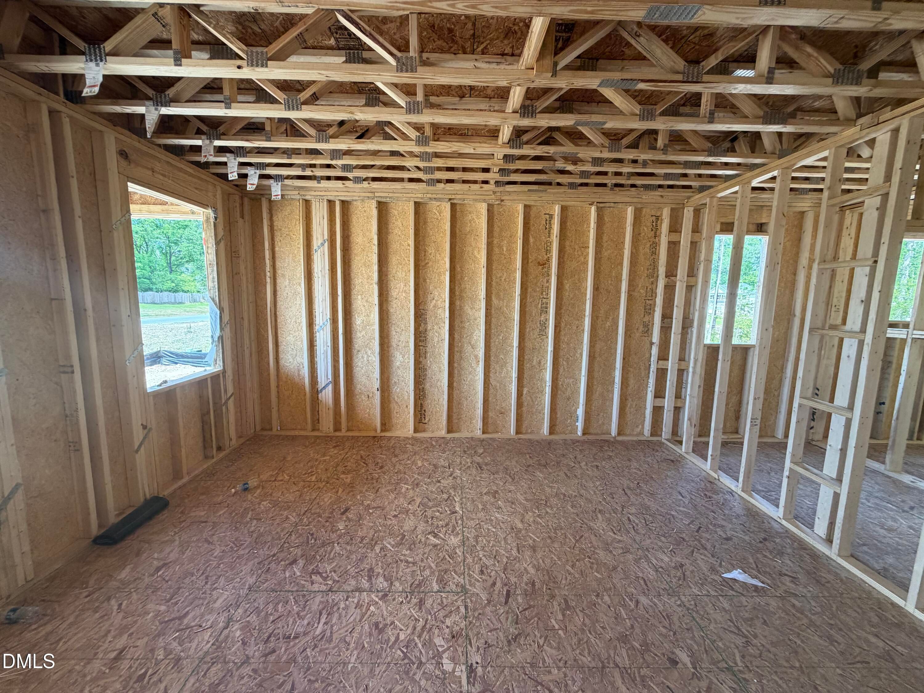 Wooden framed interior with exposed trusses, plywood subfloor, and large windows in Davidson Homes The Hickory II C, Wellers Knoll, Lillington, NC
