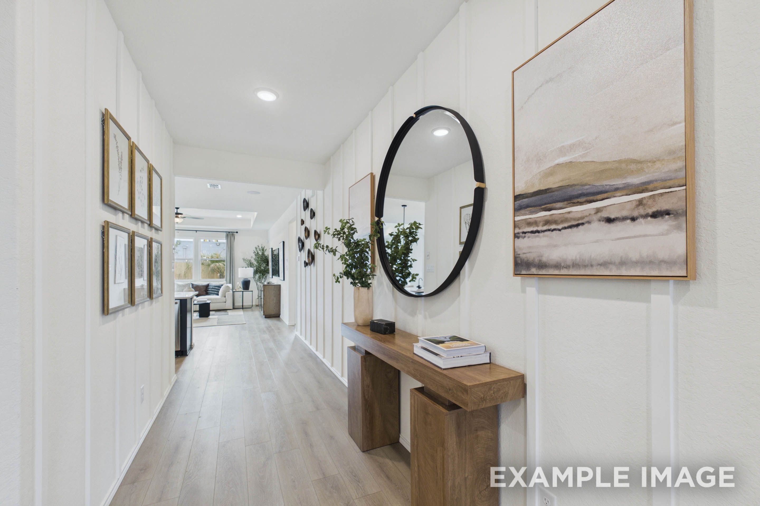 Bright entryway and hallway in The Laurel G home design featuring modern board and batten walls and wood console table.