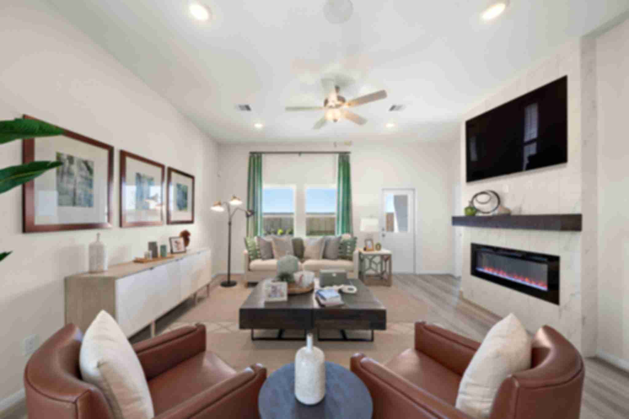 Spacious open-concept living room in River Ranch Meadows Dayton TX with hardwood floors fireplace TV and leather armchairs