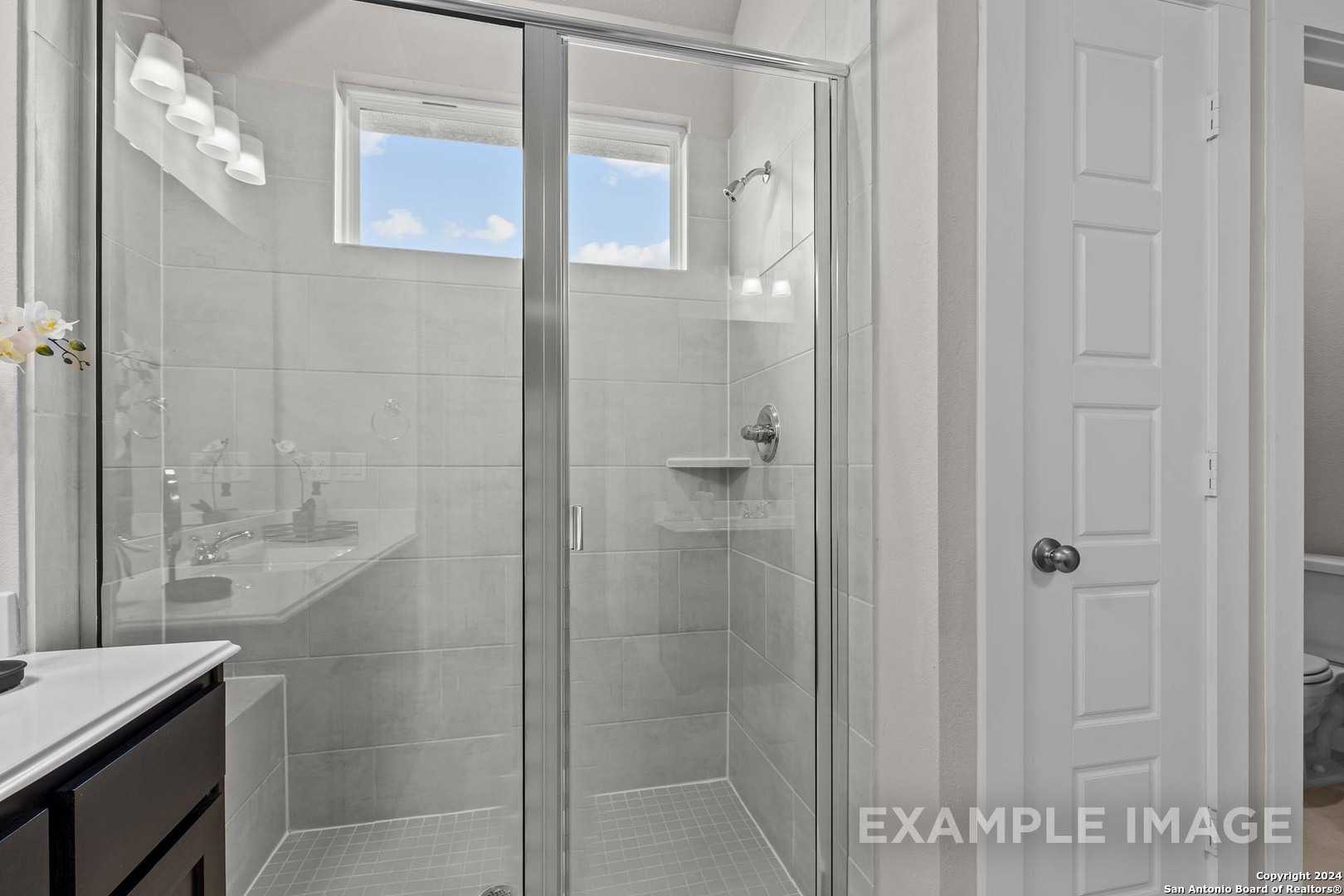Modern master bathroom with frameless glass shower, white subway tiles, and vanity in The Collin A, Davidson Homes, Seguin, TX