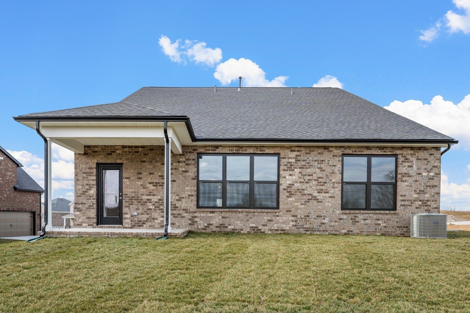 Two-story brick home with covered porch, large windows, and green yard in Benders Cove, Mt. Juliet, Tennessee, Davidson Homes Ridgeport D