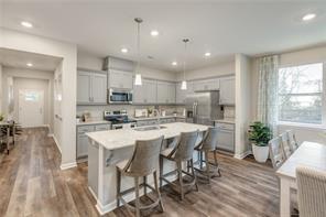 Modern kitchen with island seating in The Aurora A floor plan at Links Crossing, Auburn, Alabama.