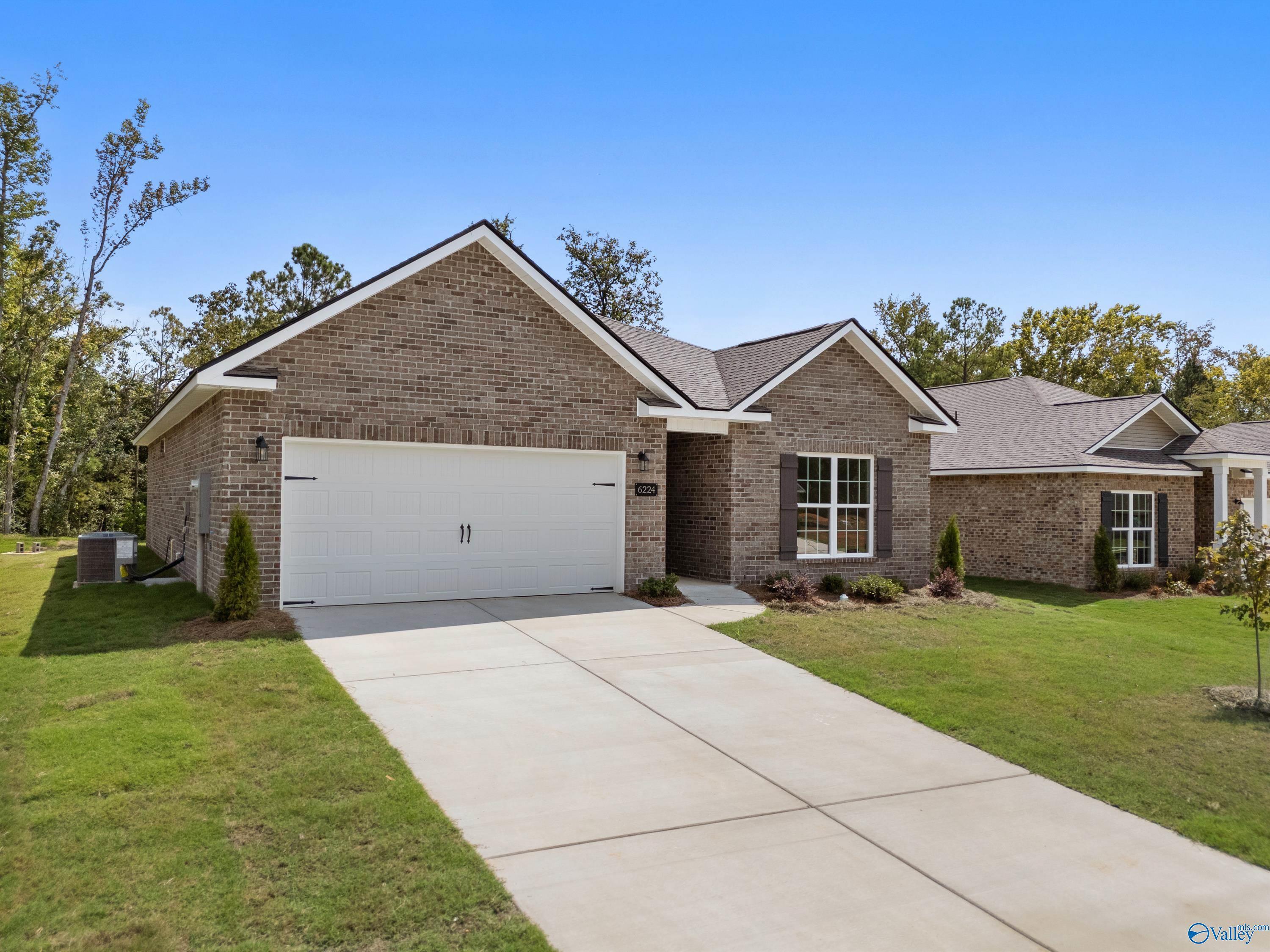 Brick 1-story home with 2-car garage, white trim, driveway, and landscaped yard in Spragins Cove, Huntsville, Alabama - Davidson Homes Asheville