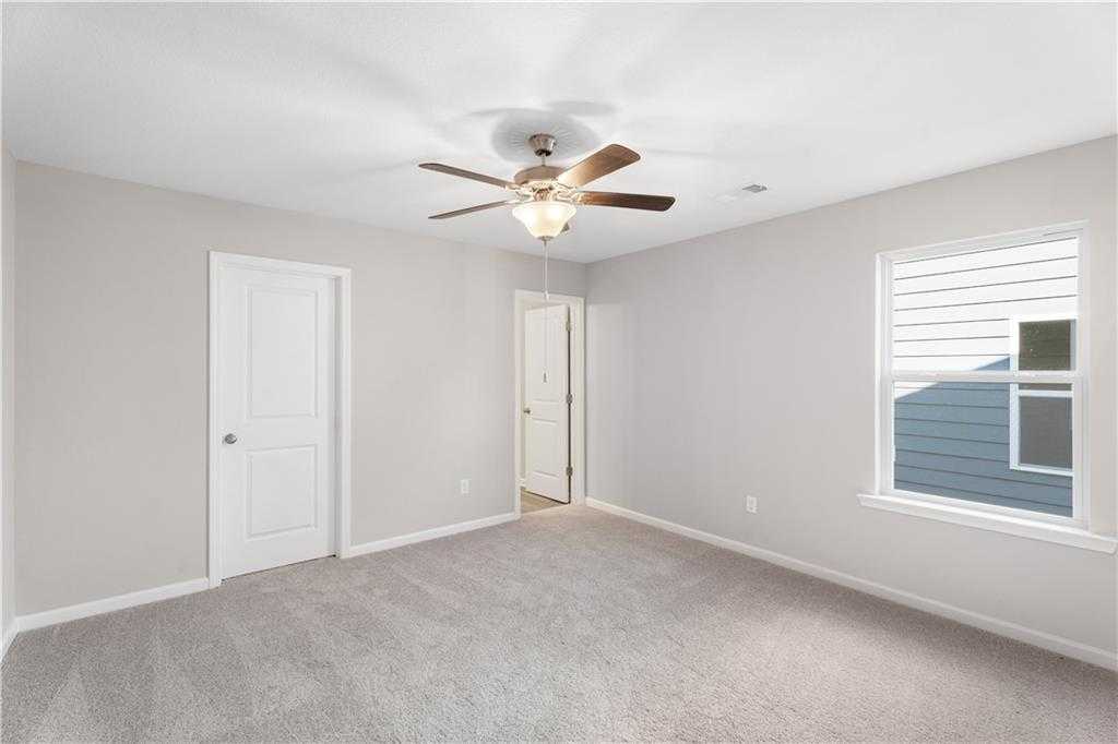 Spacious secondary bedroom with ceiling fan, gray walls, carpet, closet door, and bathroom access in Davidson Homes The Washington, Phenix City