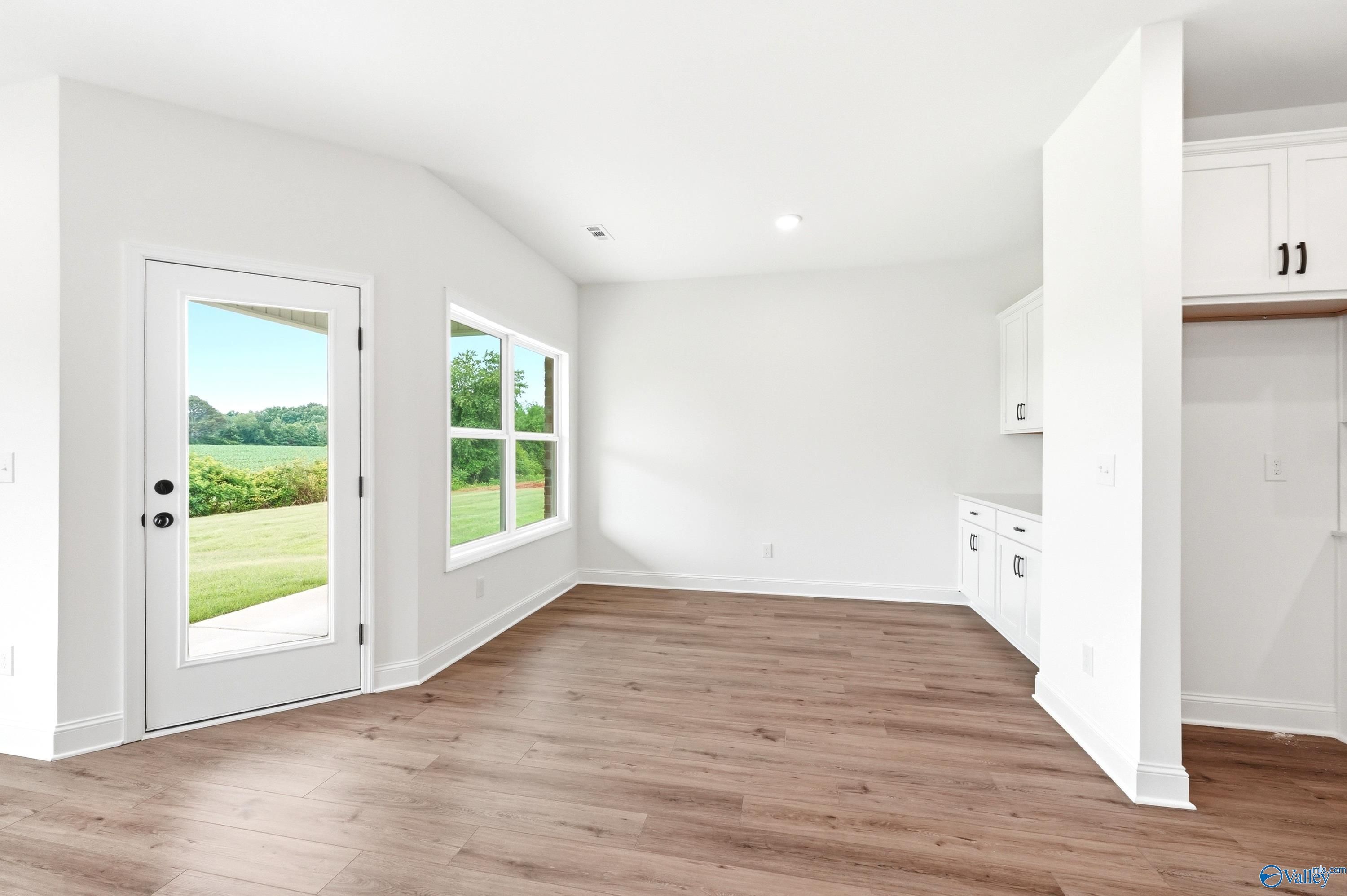 Bright breakfast nook with white cabinetry and backyard views in The Daphne C floor plan at Ivy Hills, Toney, Alabama.