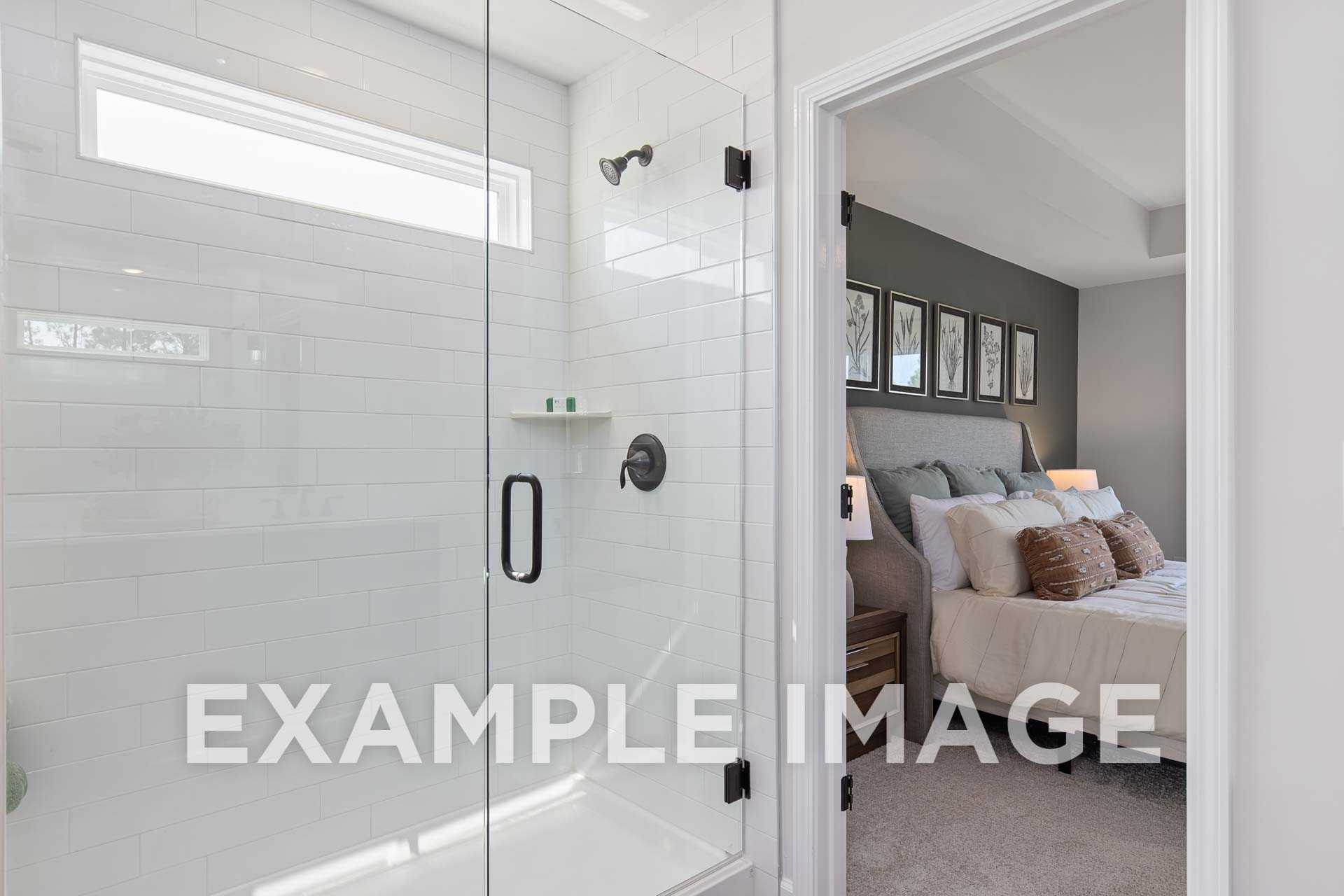 Spacious master bathroom in The Willow F with frameless glass shower, white subway tiles, and adjacent bedroom suite