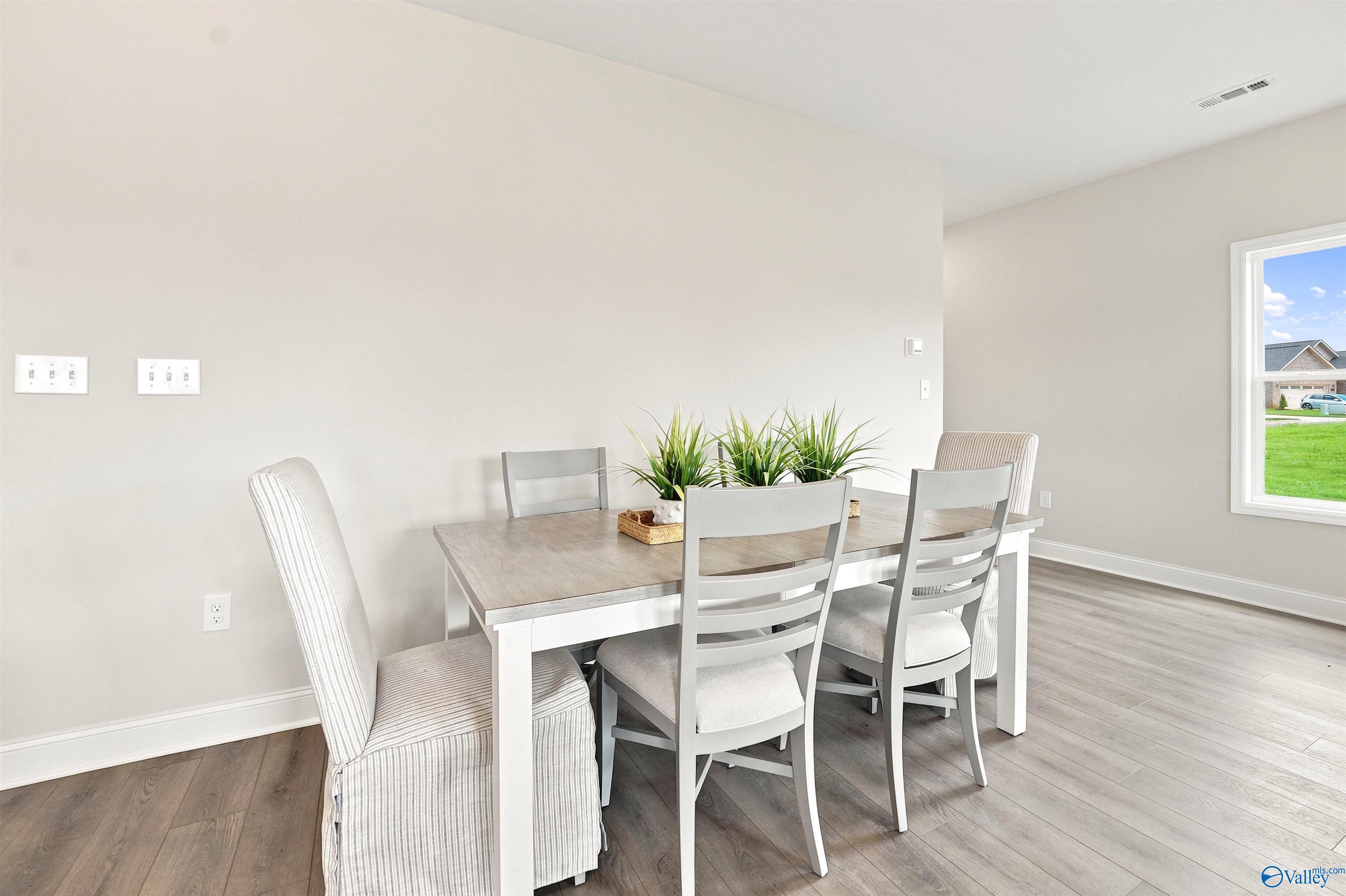 Bright dining area with modern table and chairs in The Burton B floor plan by Davidson Homes in New Market, Alabama.