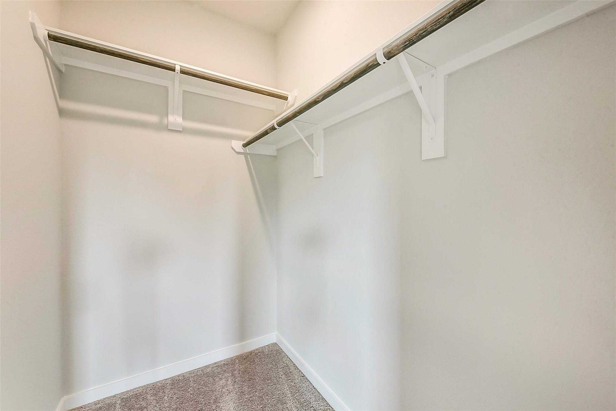 Spacious walk-in closet with double hanging rods and shelves in Davidson Homes The Comal G, Dayton, Texas