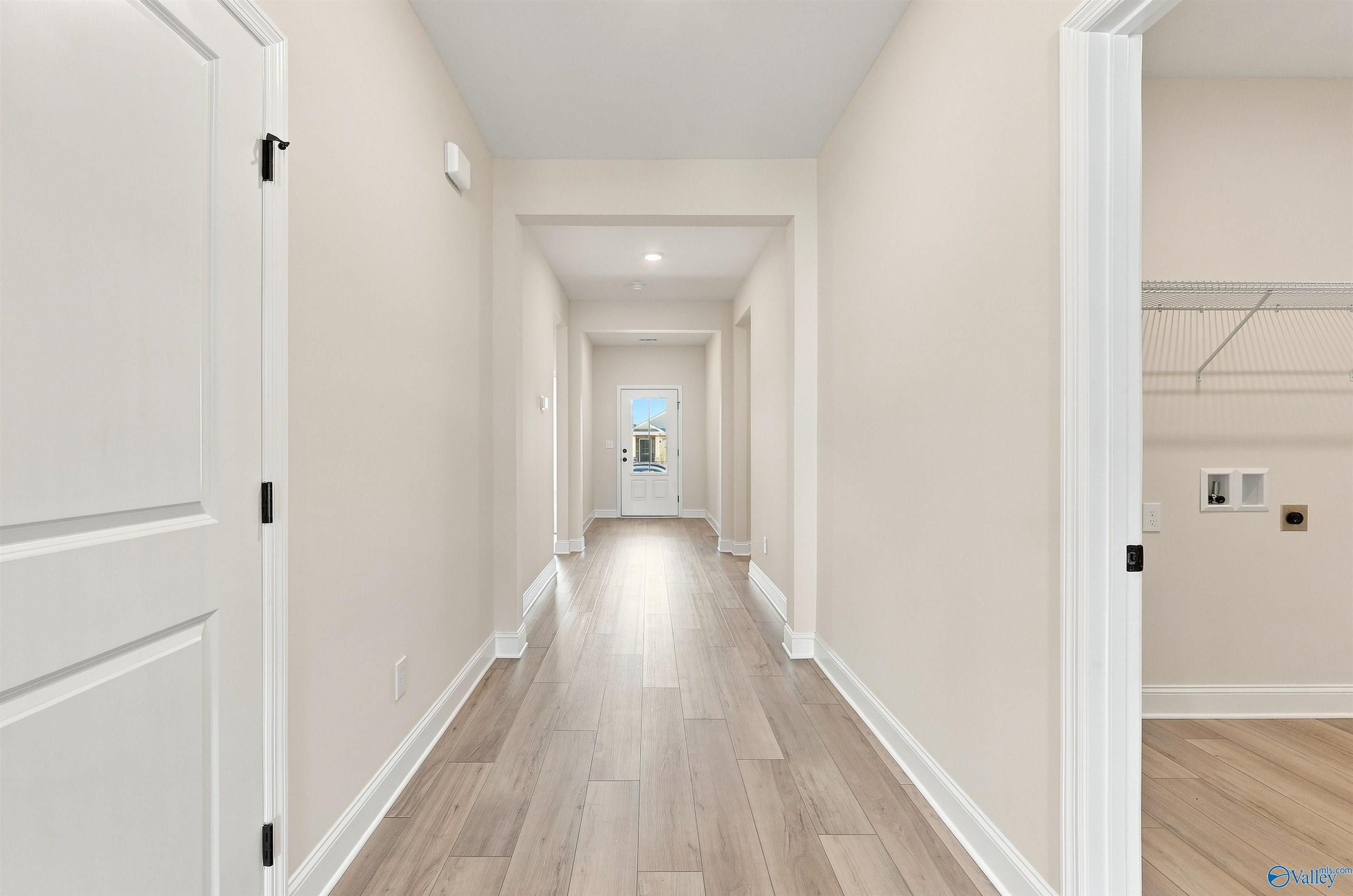 Bright hallway with luxury vinyl plank flooring leading to front door in Davidson Homes The Everett B, Ivy Hills, Toney, Alabama