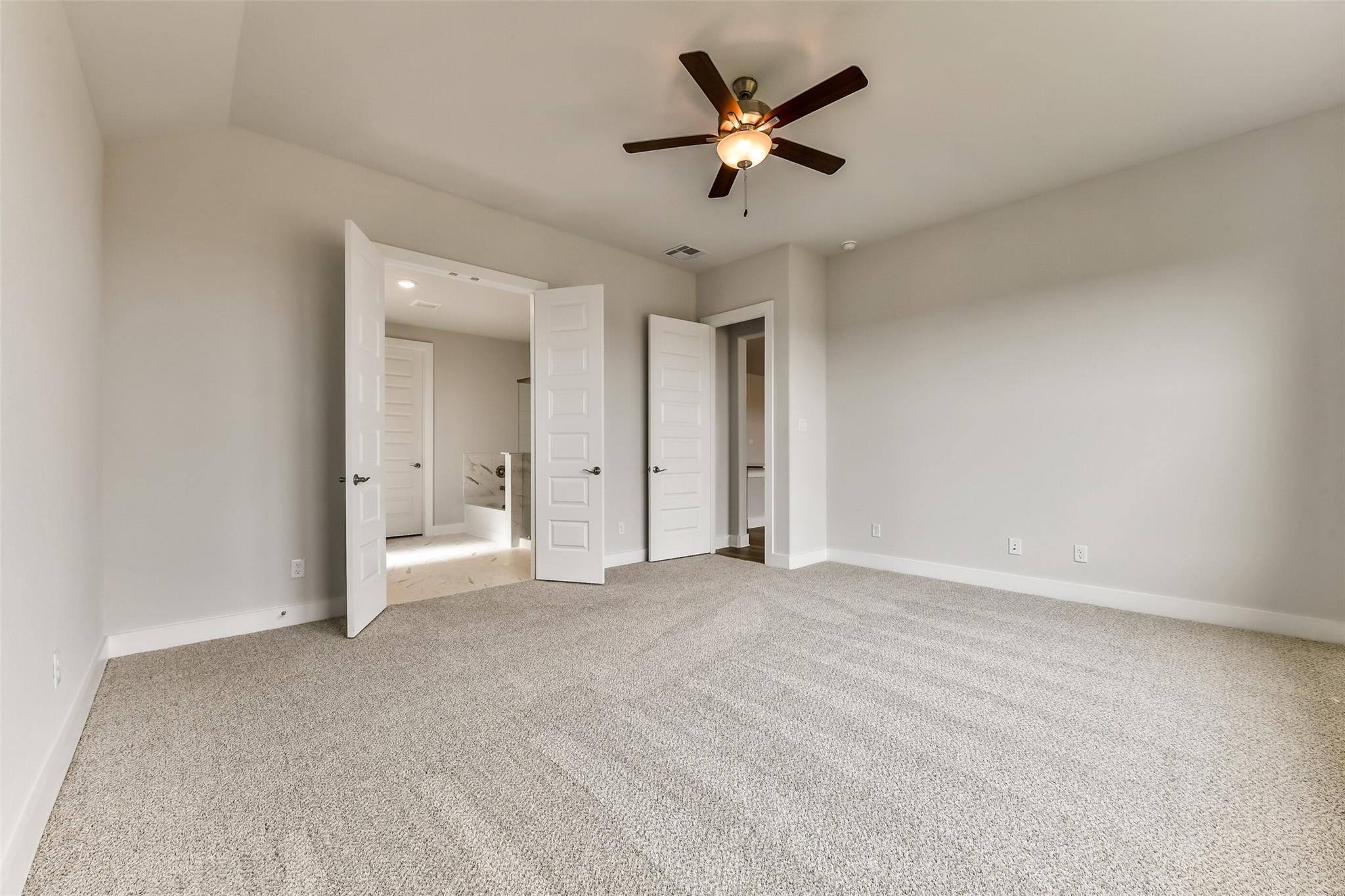 Spacious master bedroom with ceiling fan and open doors to en-suite bathroom in Davidson Homes The George A, Lago Mar, Texas City