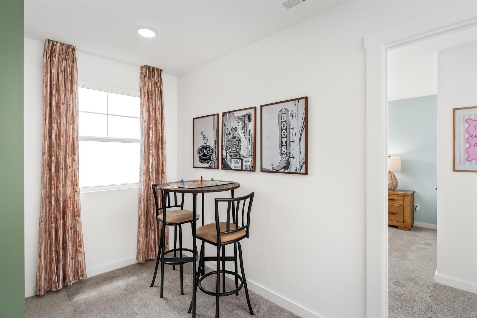 Cozy kids' play nook at Calista Farms in White House TN with round table, bar stools, orange curtains, and framed wall art