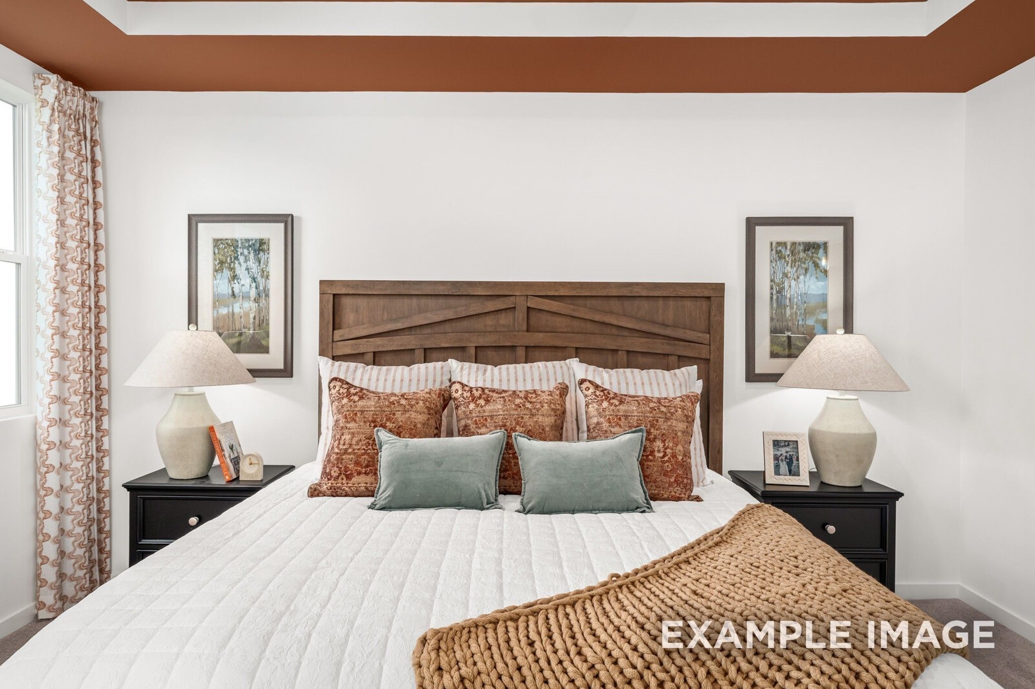 Cozy bedroom with wooden headboard and tray ceiling in The Ash A floor plan at Woods Crossing, Gallatin, Tennessee.