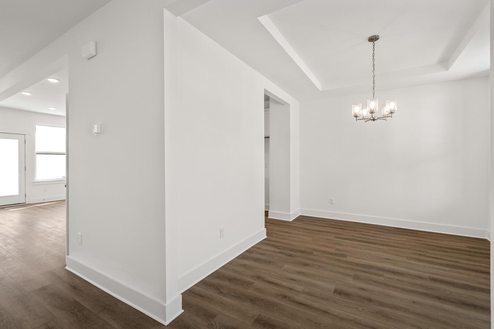 Elegant foyer with chandelier, white walls, and hardwood floors in Davidson Homes The Willow D, Mt. Juliet, TN