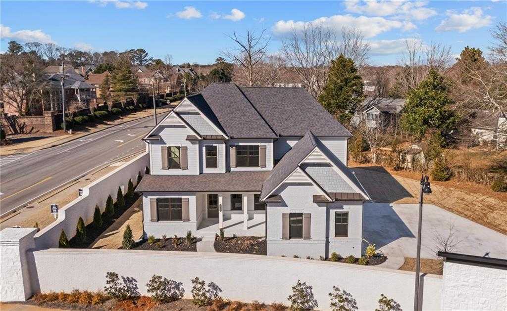 Two-story Arlington A home by Davidson Homes in Tanglewood, East Cobb, Georgia, featuring white siding, dark shingled roof, and landscaped yard