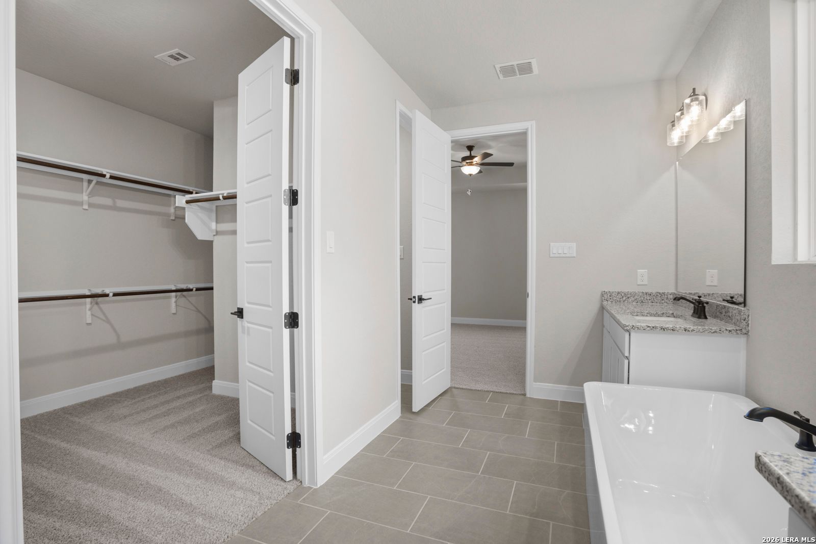 Master bathroom with soaking tub, vanity, and walk-in closet in The Jennings G floor plan at Ladera, San Antonio.