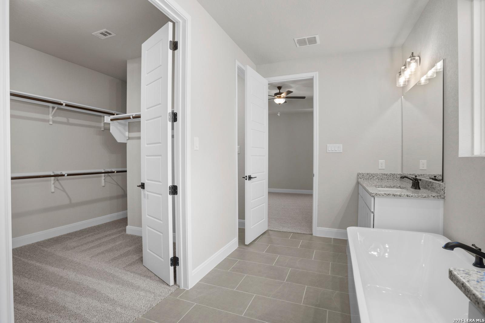 Master bathroom with soaking tub, vanity, and walk-in closet in The Jennings G floor plan at Ladera, San Antonio.
