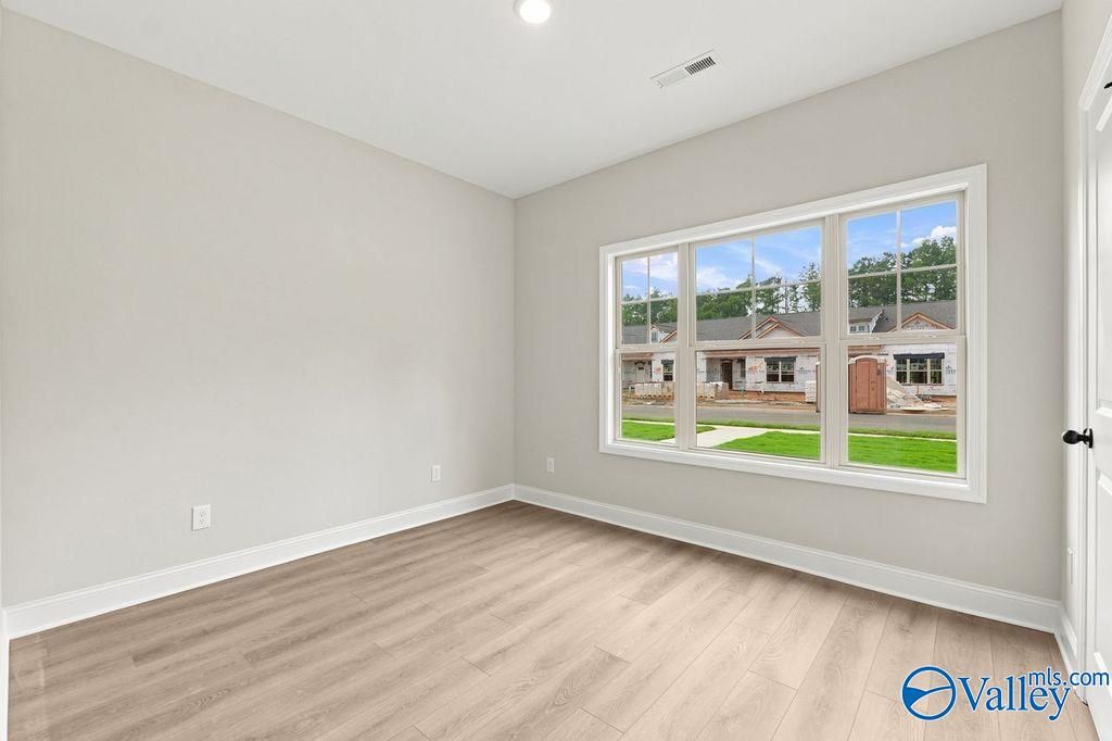 Bright bedroom with light wood flooring and large windows in The Camilla C floor plan at The Retreat at Cain Park, Hartselle.