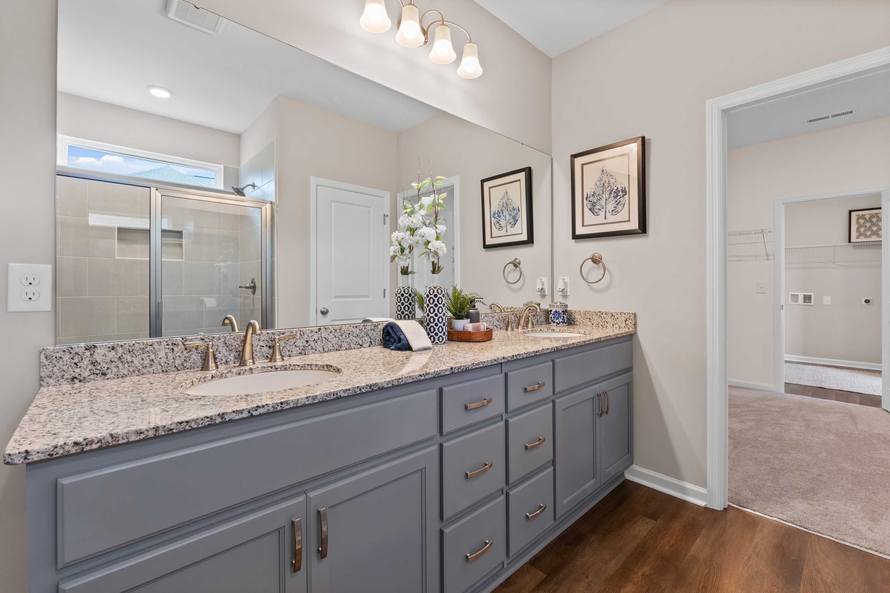 Spacious modern bathroom at Riverton Preserve in Huntsville AL with double vanity, gray cabinets, granite counters and walk-in shower