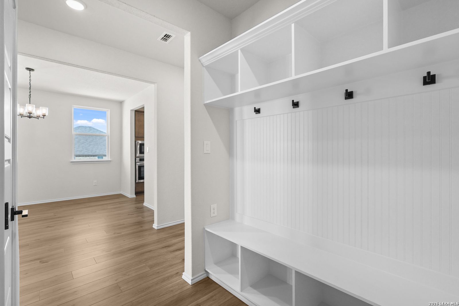 Mudroom with built-in bench, cubbies, coat hooks and wood-look flooring in Davidson Homes Glenwood E plan, Comanche Ridge, San Antonio